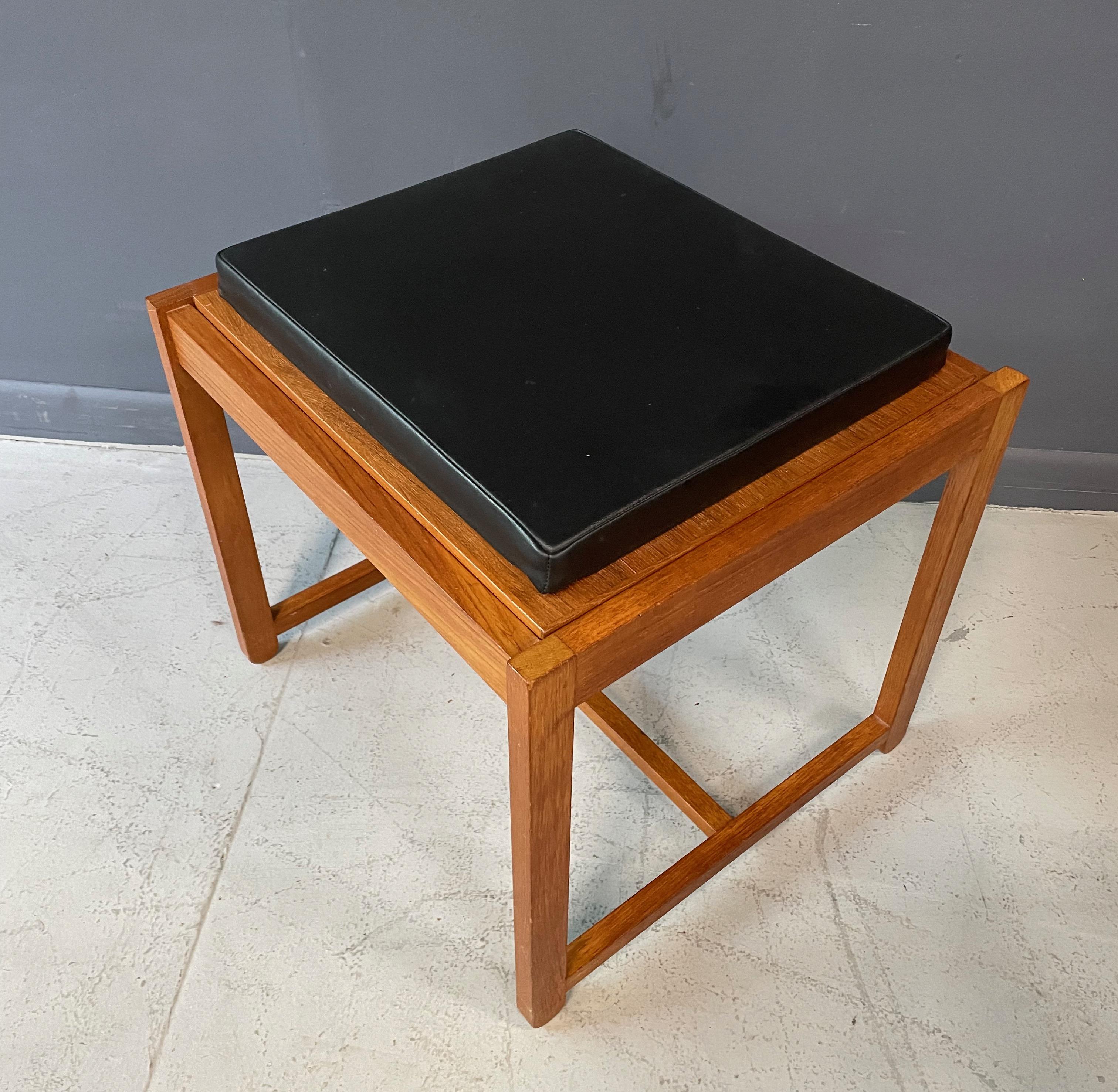 Designed in 1957 by Erik Buch. This piece has a wonderful architectural quality about it. This is a reversible stool or makes great side table. Made in Odense, Denmark. The leather is still soft and supple, the teak is in great shape.