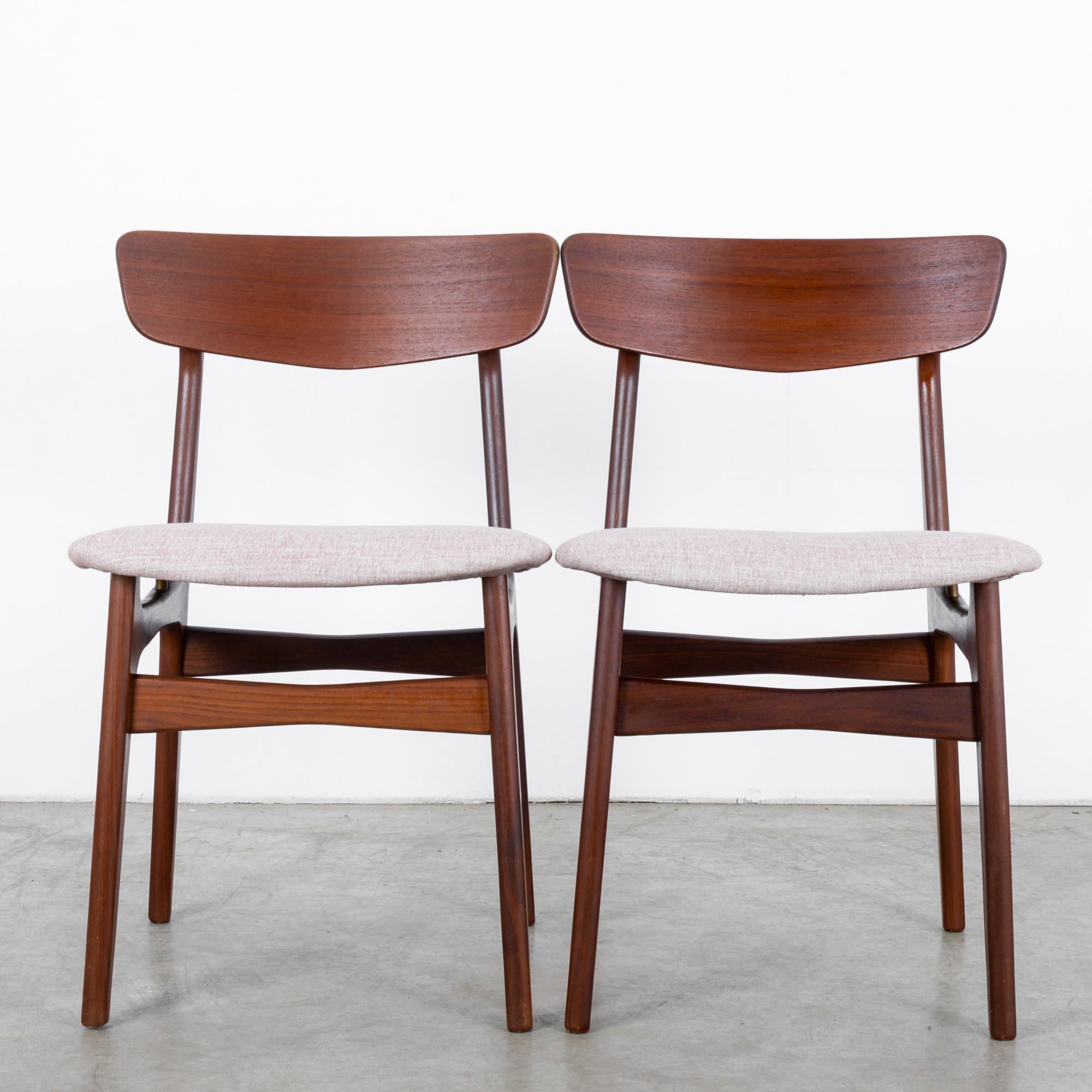 This pair of teak chairs by Glostrup was made in Denmark, circa 1960. The chairs are supported on tapered legs and feature a curved backrest. Details such as the slight narrowing of the stretchers in the middle add refinement. Pale ash pink