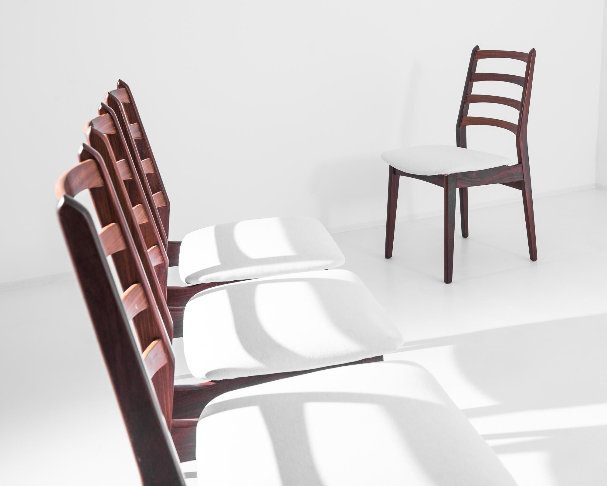 Wir stellen vier dänische Teakholzstühle aus den 1960er Jahren vor, die die Essenz des skandinavischen Designs verkörpern - schlicht, schlank und äußerst stilvoll. Diese Stühle zeichnen sich durch ein reiches, warmes Teakholzgestell mit fließenden