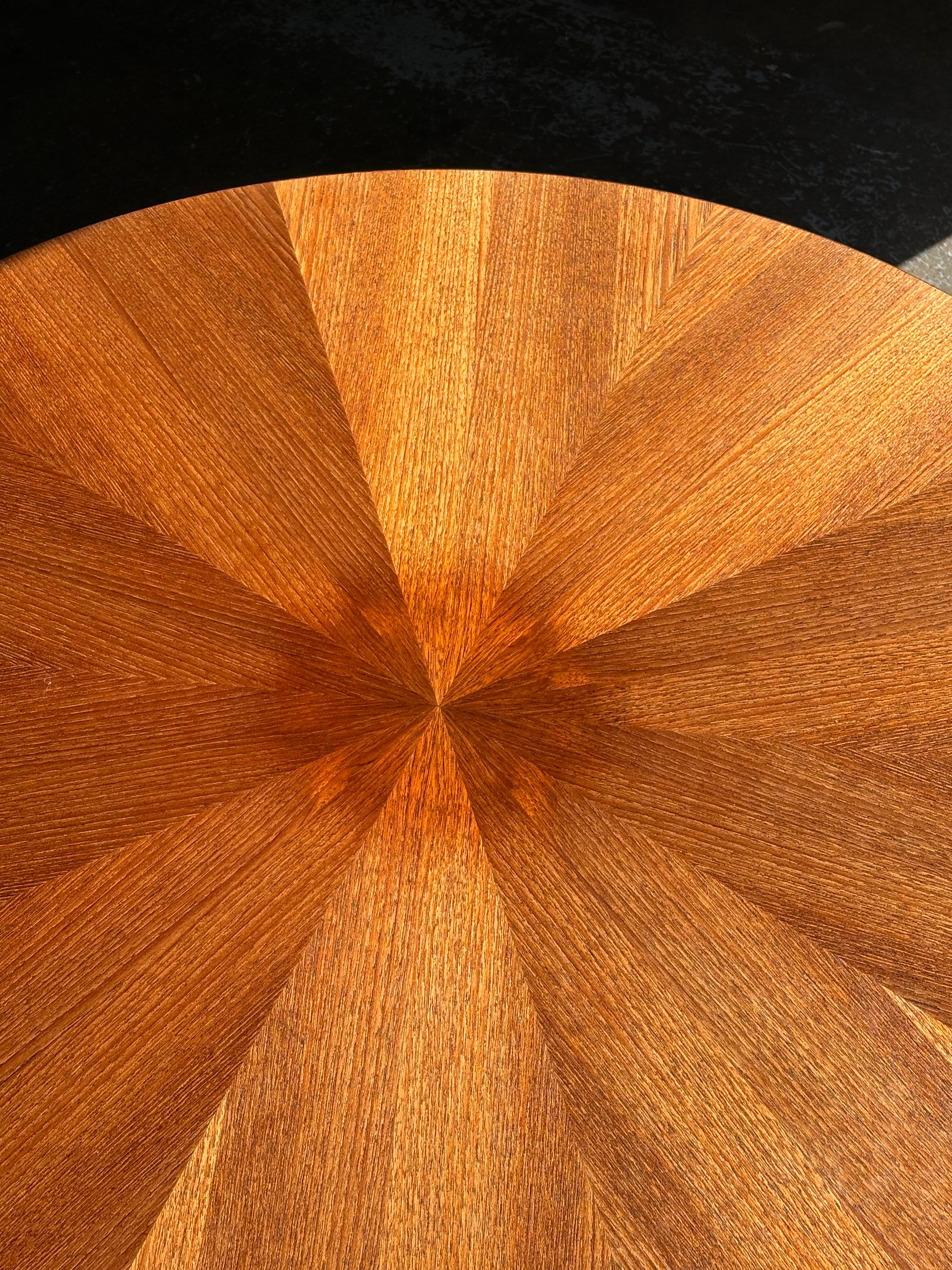 A striking 1960s Danish teak coffee table by George Jensen, where sculptural design meets timeless craftsmanship. The round top showcases a radiant sunburst veneer, while the bold interlocking base gives the piece its architectural presence. Equal