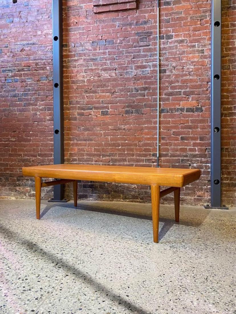 Incredible high quality Danish teak coffee table designed by Johannes Andersen for CFC Silkeborg circa 1960s. This piece has large drawers at either end and clever coasters that pop in and out of little slots on one side. The entire piece is freshly