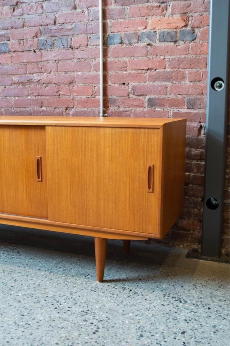 Fresh to our showroom is a super clean 1960s teak credenza with three sliding doors, adjustable shelving, and nice tapered legs. The entire piece is freshly restored and in excellent condition. 

63” long 
29.5” high
18” deep

Free local delivery.