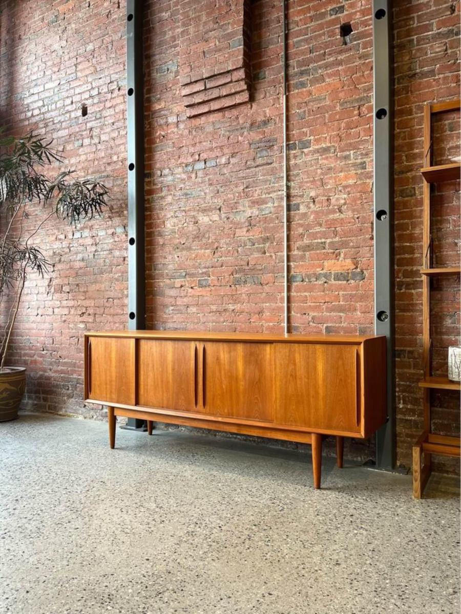 We are thrilled to offer this exquisite 1960 Danish teak credenza, crafted by the renowned designer Svend Madsen. Featuring a distinctive curved front, this credenza exudes elegance and sophistication, adding a touch of organic charm to any interior