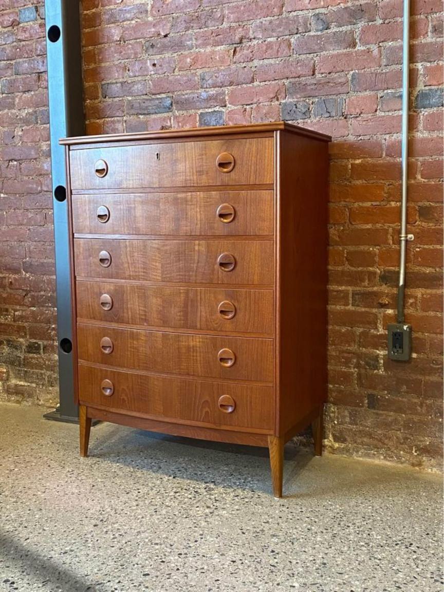 Discover one of the most elegant dressers in our collection—a 1960s Danish teak dresser with a gracefully curved front, exquisite teak pulls, and ample storage space. Meticulously restored by our team, this piece is in excellent condition,