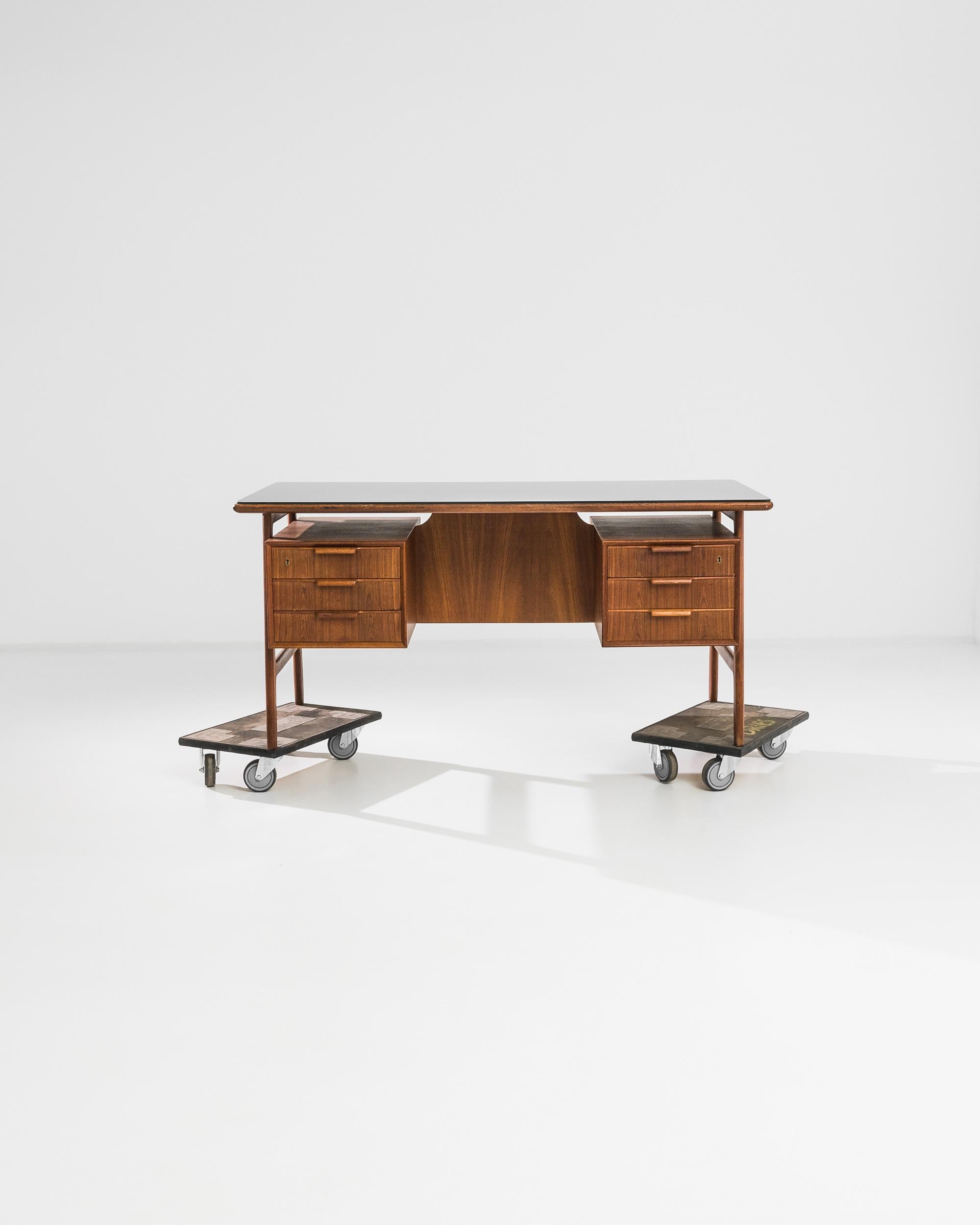 A Midcentury Modern desk by Danish designer Omann Jun. Made in the 1960s in teak, this piece epitomizes the clean lines and expert craftsmanship for which the designer is known. The floating design of the drawers creates additional space underneath