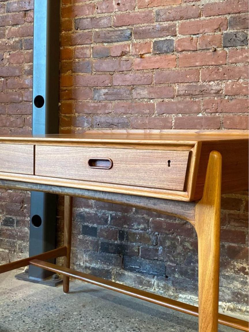 Beautifully crafted Danish teak desk by Svend Madsen for Sigurd Hansen, circa 1960s. Adorned with a pair of spacious drawers, elegant angular design, and finished on all sides. Recently restored by our team, it's in superb condition, with only a few
