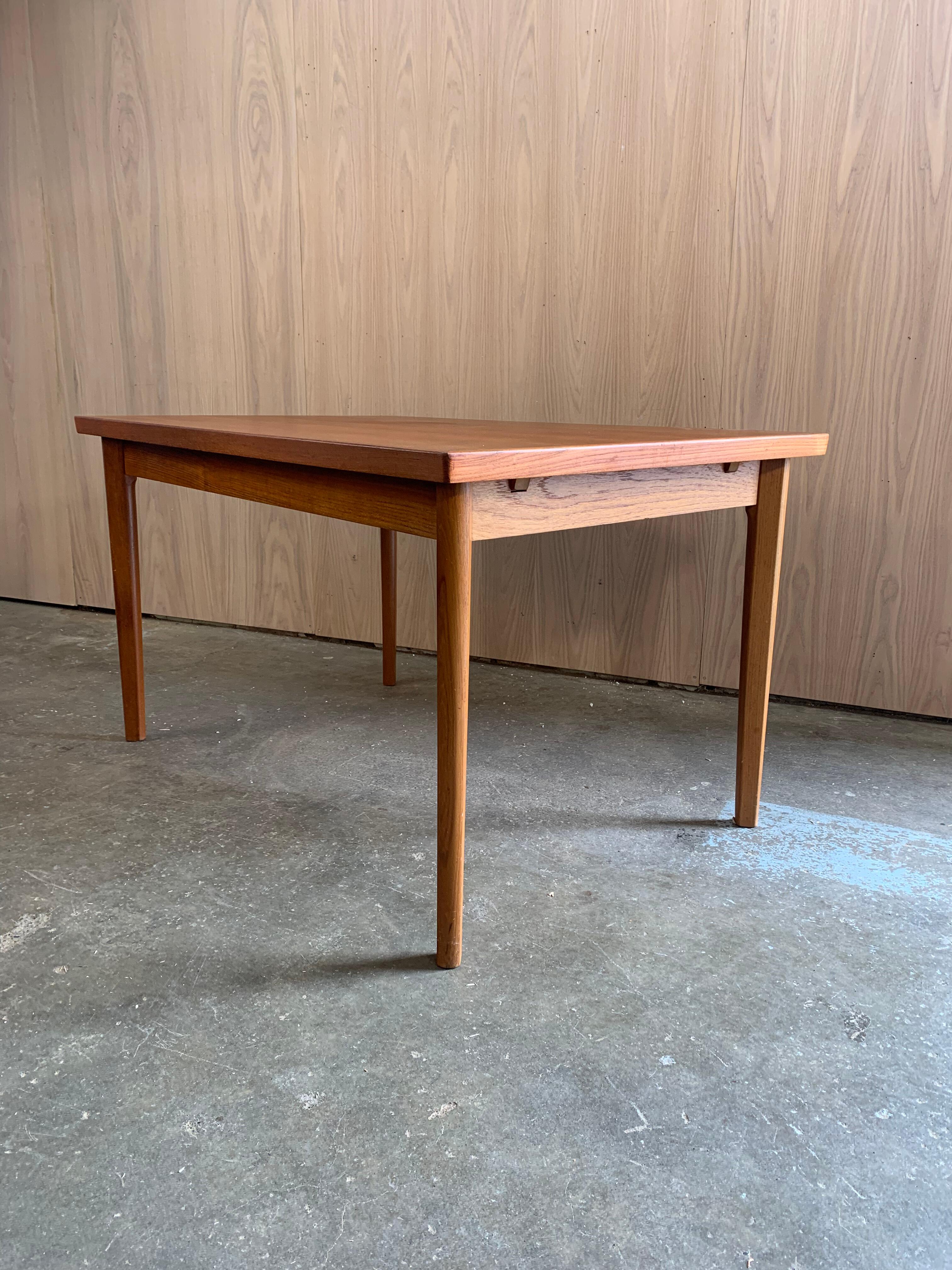 A clean and clever example of Danish design, this 1960s teak dining table by Vejle Stole Møbelfabrik combines warmth, craftsmanship, and functionality in a compact package. Its understated silhouette and beautifully grained teak surface make it a