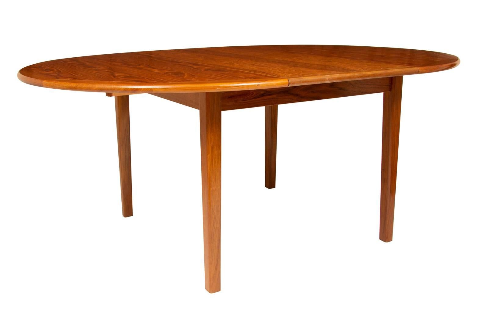 A beautiful teak dining table with four removable legs and one insert. Made in Denmark by Vejle Stole. The dining table can be extended to 180cms long with the additional insert. Very well made and solidly constructed the table has a striking