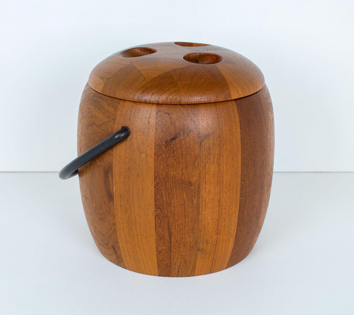 1960s Danish teak ice bucket by Digsmed, a small Danish company producing high quality homeware in the 1960s and 1970s. It is made of curved staved teak with a cast iron handle, distinctive bowling ball style handle and black plastic liner.
