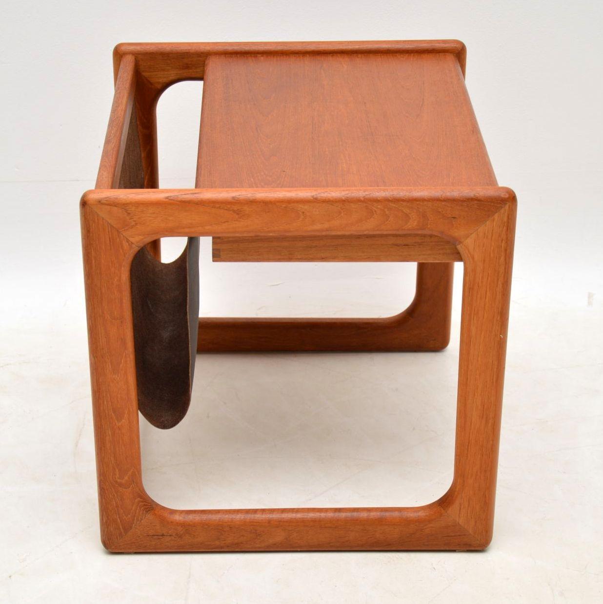 A stylish and top quality vintage Danish side table in teak, with a built in leather magazine rack, it dates from the 1960s-1970s. This is really well made, and is in great condition for its age, with only some extremely minor wear here and
