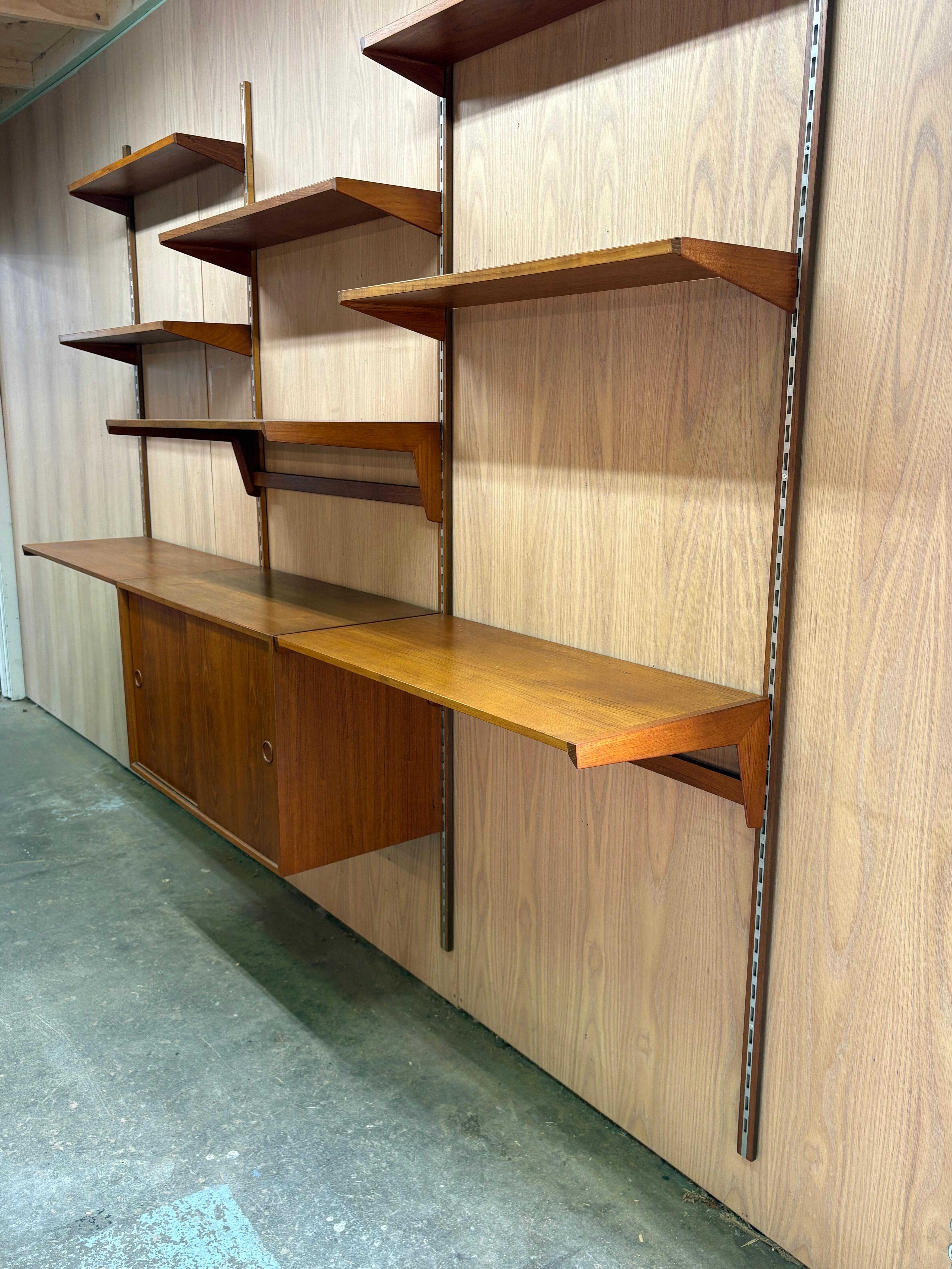 A superb 1960s teak modular wall system designed by Kai Kristiansen for FM Møbler, Denmark. This system exemplifies the refined functionality and timeless elegance of Danish modern design, offering a versatile arrangement of open shelving and