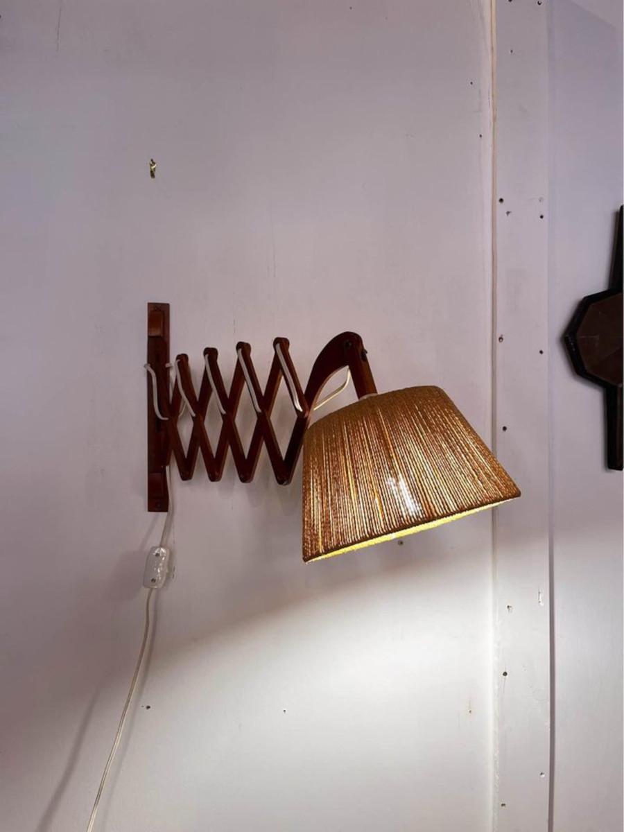 Elevate your living space with the timeless elegance of this 1960's Ib Fabiensen for Fog and Morup Teak Scissor Wall Lamp, a quintessential piece of mid-century modern design. Featuring a teak wood scissor arm, the lamp exudes warmth and natural