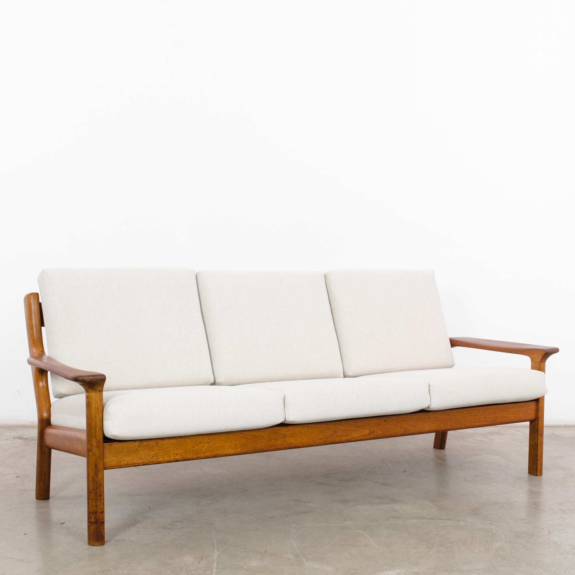 In the dynamic design landscape of 1960s Denmark, this teak sofa by Svend Age Eriksen for Glostrup Møbelfabrik epitomizes the sleek sophistication and minimalist charm of the era. Crafted with meticulous attention to detail, this piece represents