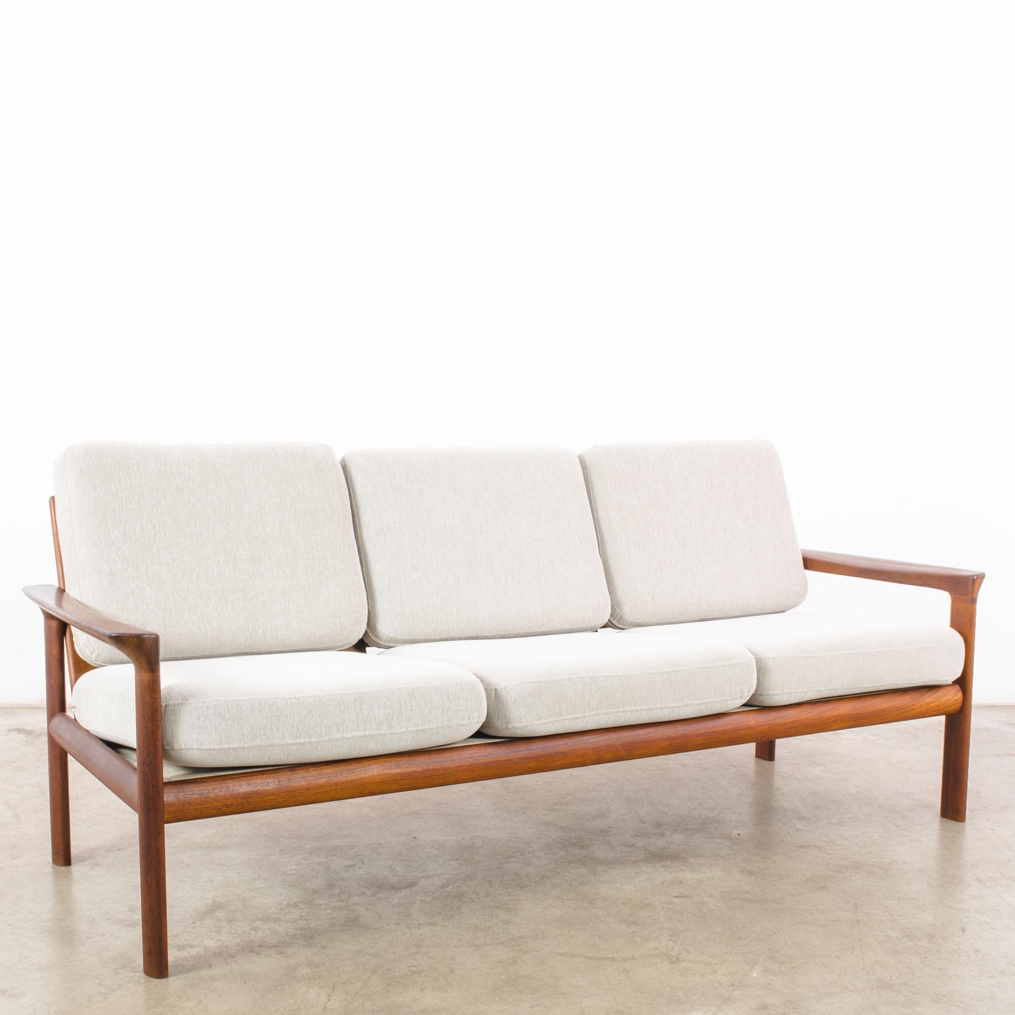 In the dynamic design landscape of 1960s Denmark, this teak sofa epitomizes the sleek sophistication and minimalist charm of the era. Crafted with meticulous attention to detail, this piece represents the epitome of Danish craftsmanship and style