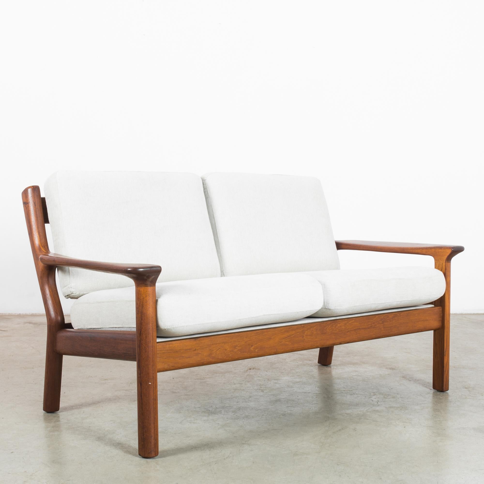 Dive into the Danish modern movement with this sleek 1960s teak sofa that effortlessly marries form and function. Its clean lines and warm teak frame echo the minimalist aesthetic that Danish design is celebrated for. The sofa's frame features