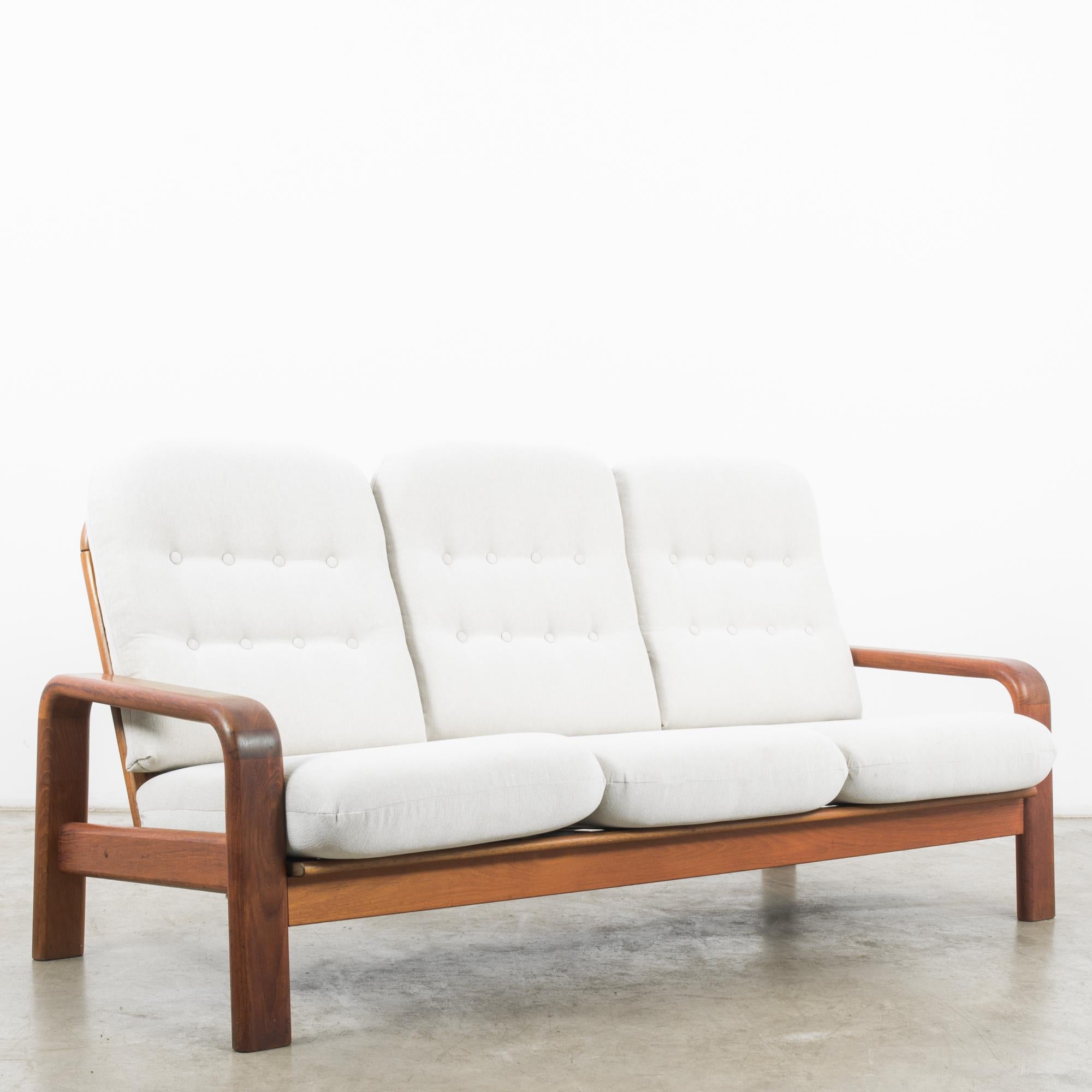 In the dynamic design landscape of 1960s Denmark, this teak upholstered sofa epitomizes the sleek sophistication and minimalist charm of the era. Crafted with meticulous attention to detail, this piece represents the epitome of Danish craftsmanship