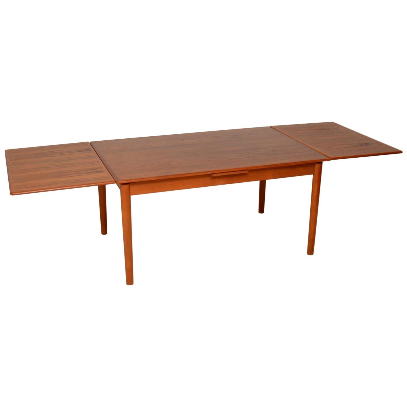 A beautiful and top quality vintage Danish extending dining table in teak, dating from the 1960s-1970s. This is really well made, it has two drawer leaves that can be pulled out to extend this to a ten seater. It is also possible to pull out one