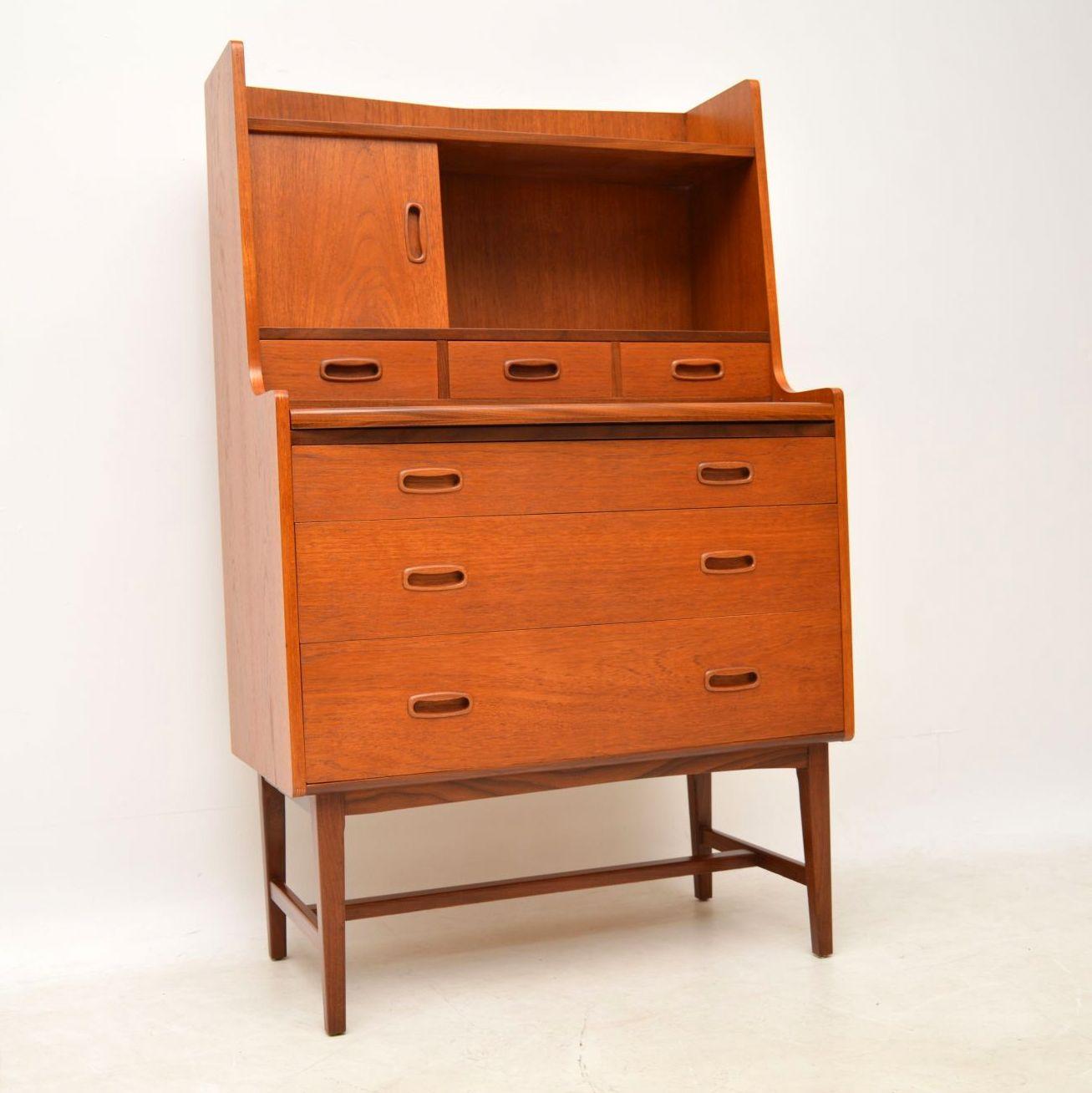 A stylish and practical vintage Danish bureau in teak, this dates from the 1960s. It’s a great size, with a pullout / pull-out writing slide and lots of storage compartments. There are drawers in the bottom and middle, a sliding door cabinet in the