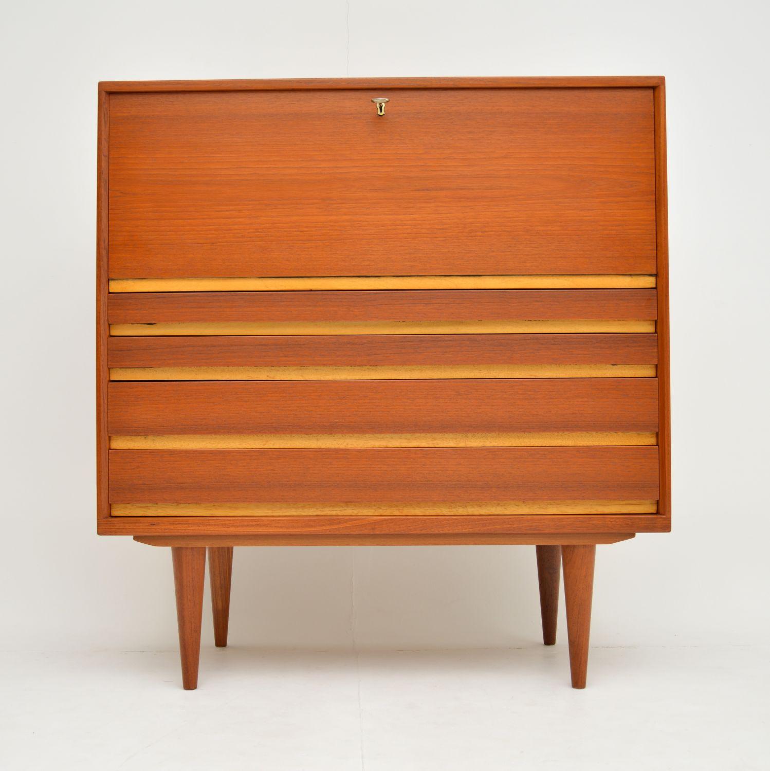A stunning and very practical vintage Danish writing bureau in teak. This dates from the 1960s, it is of amazing quality has lots nice features.

The top drops down to reveal a large writing area with pigeon hole storage. The lower half consist of