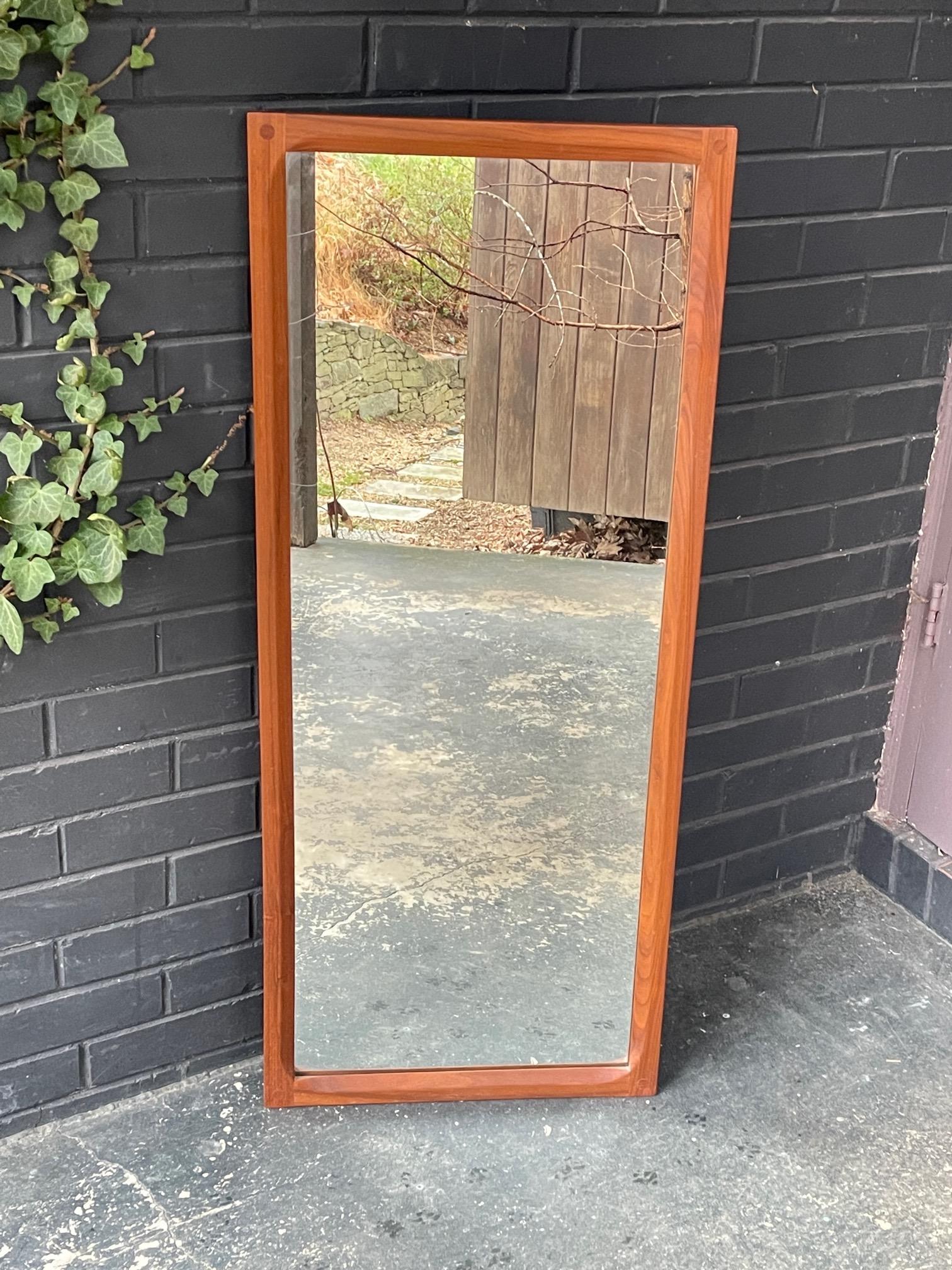 Estate fresh, a solid teak framed wall mirror, with angled and doweled details. In good vintage condition, makers markings to verso. 

Two are available, one per list price.