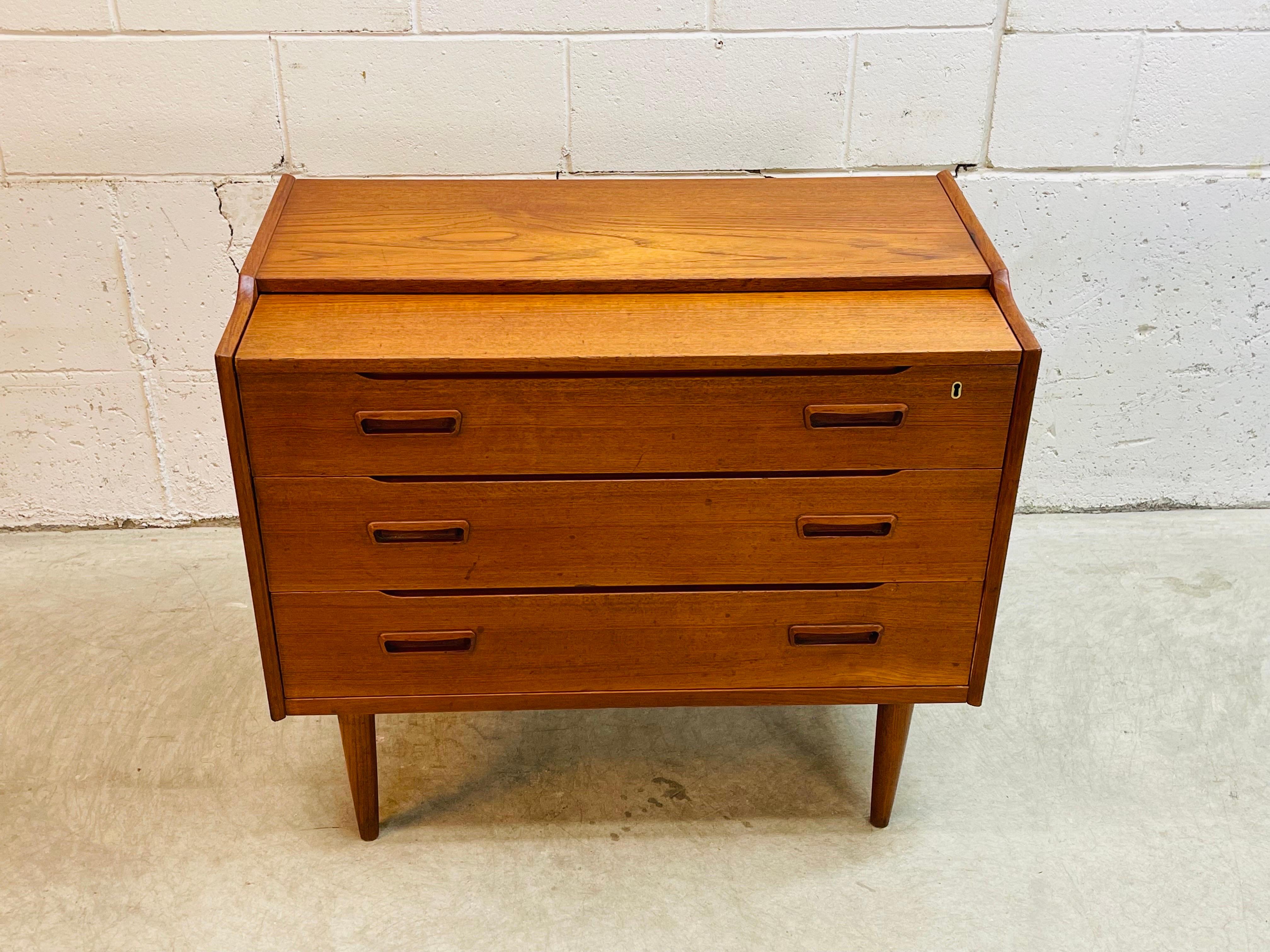 Vintage 1960s Danish teak wood vanity and storage cabinet. Vanity has two drawers for storage amd the drawers are 5.25”H. Top drawer pulls out to reveal a full vanity set yp with mirror and compartment storage. Vanity is in original condition and is