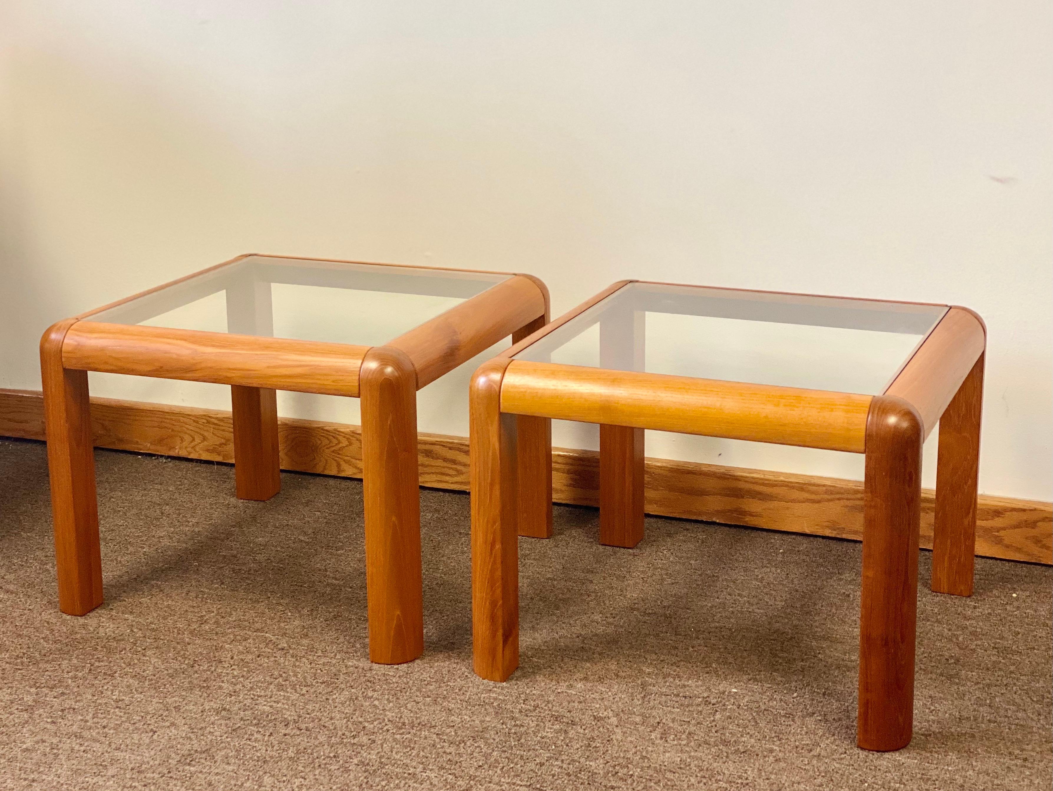We are very pleased to offer a Mid-Century Modern pair of side tables by Trioh-Mobler, made in Denmark, circa the 1960s. Constructed from teak wood and clear inset glass tops, this strikingly modern pair will cause an impression with its uprights
