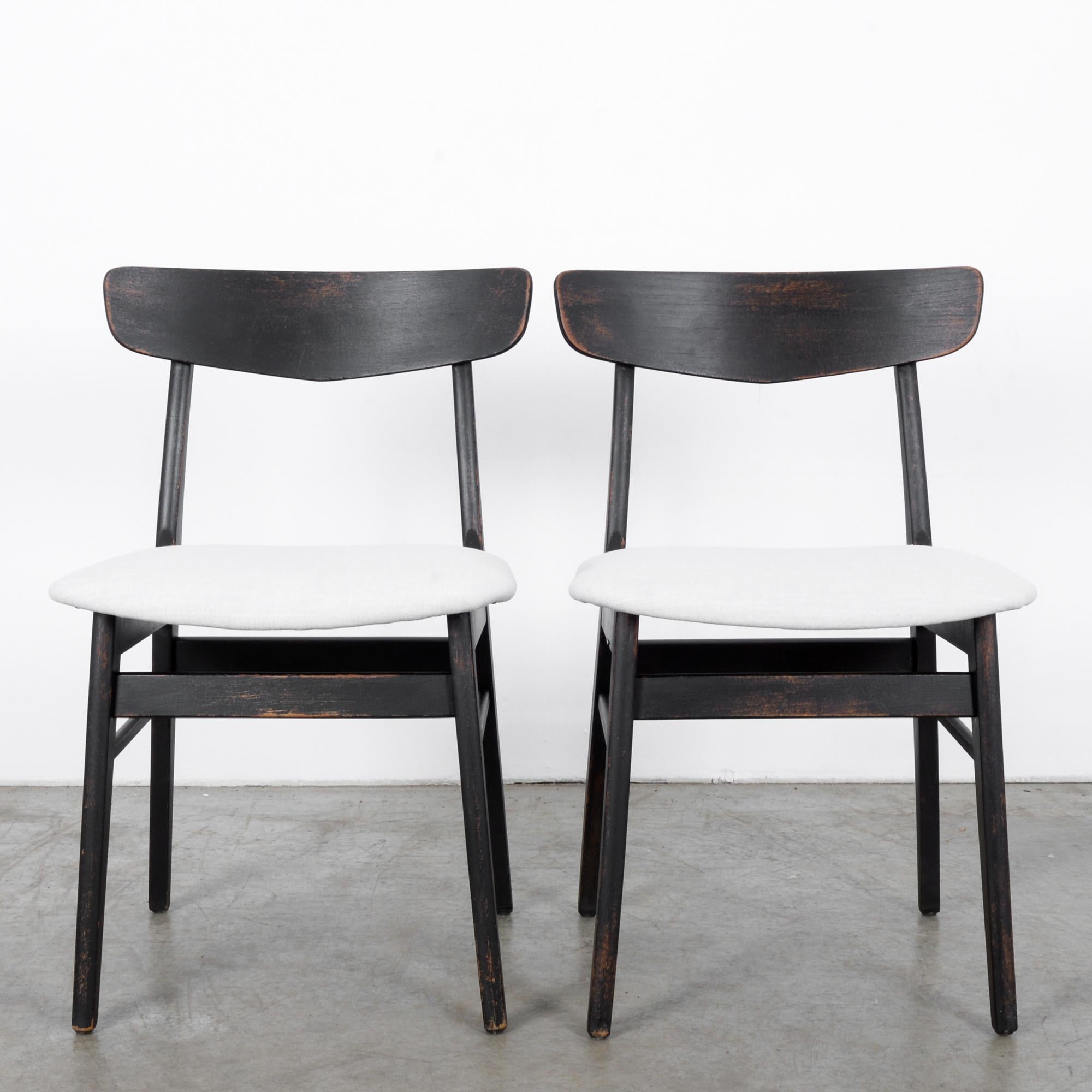 Exemplary pair of Danish black patinated wood upholstered seats, from the 1960s. White re-upholstered seats contrast beautifully with the dark patinated finish of the black wood. Following in the tradition of mid-century design, the clean modern