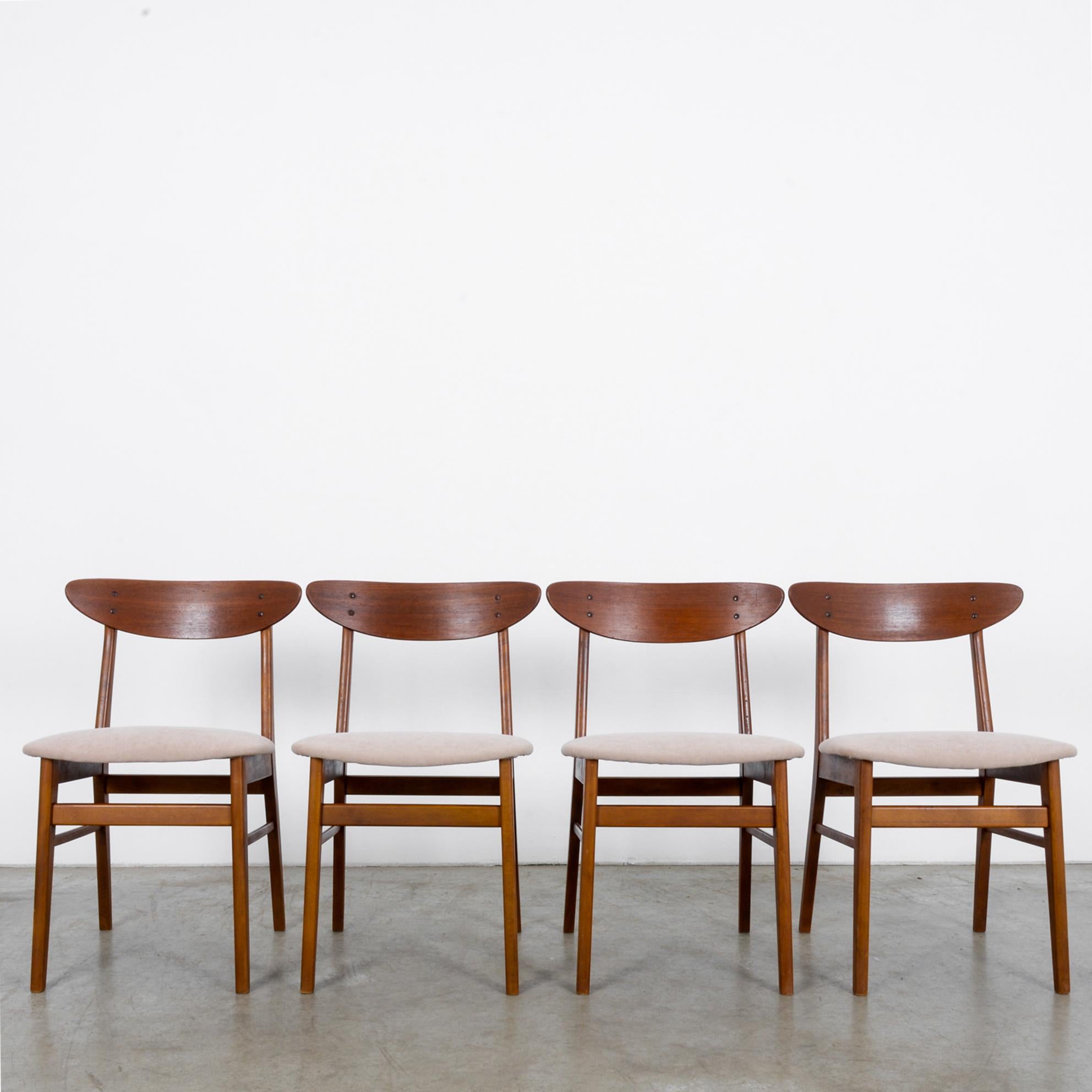 This set of four chairs from Denmark circa 1960 is Classic Scandinavian Modern design. Freshly re-upholstered and looking like the seat backs were scooped raw off the side of a tree, the sleek clean lines of these chairs will add grace to any