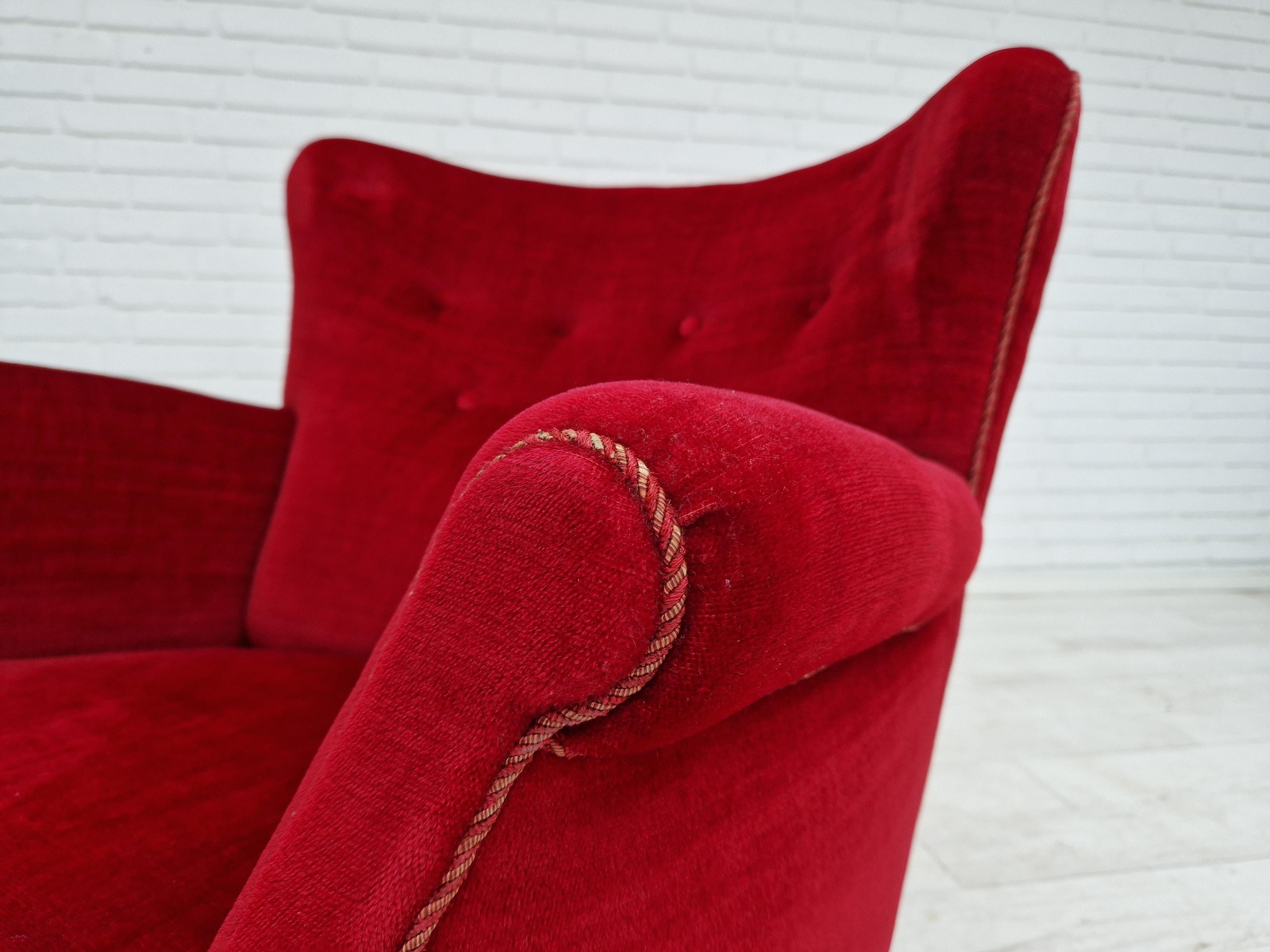 Vintage lounge chair of Danish design. Made around 1960 by a Danish furniture manufacturer. Original cherry-red velvet upholstery in very good condition, no stains, no smells. Legs in beech. Brass springs in the seat.