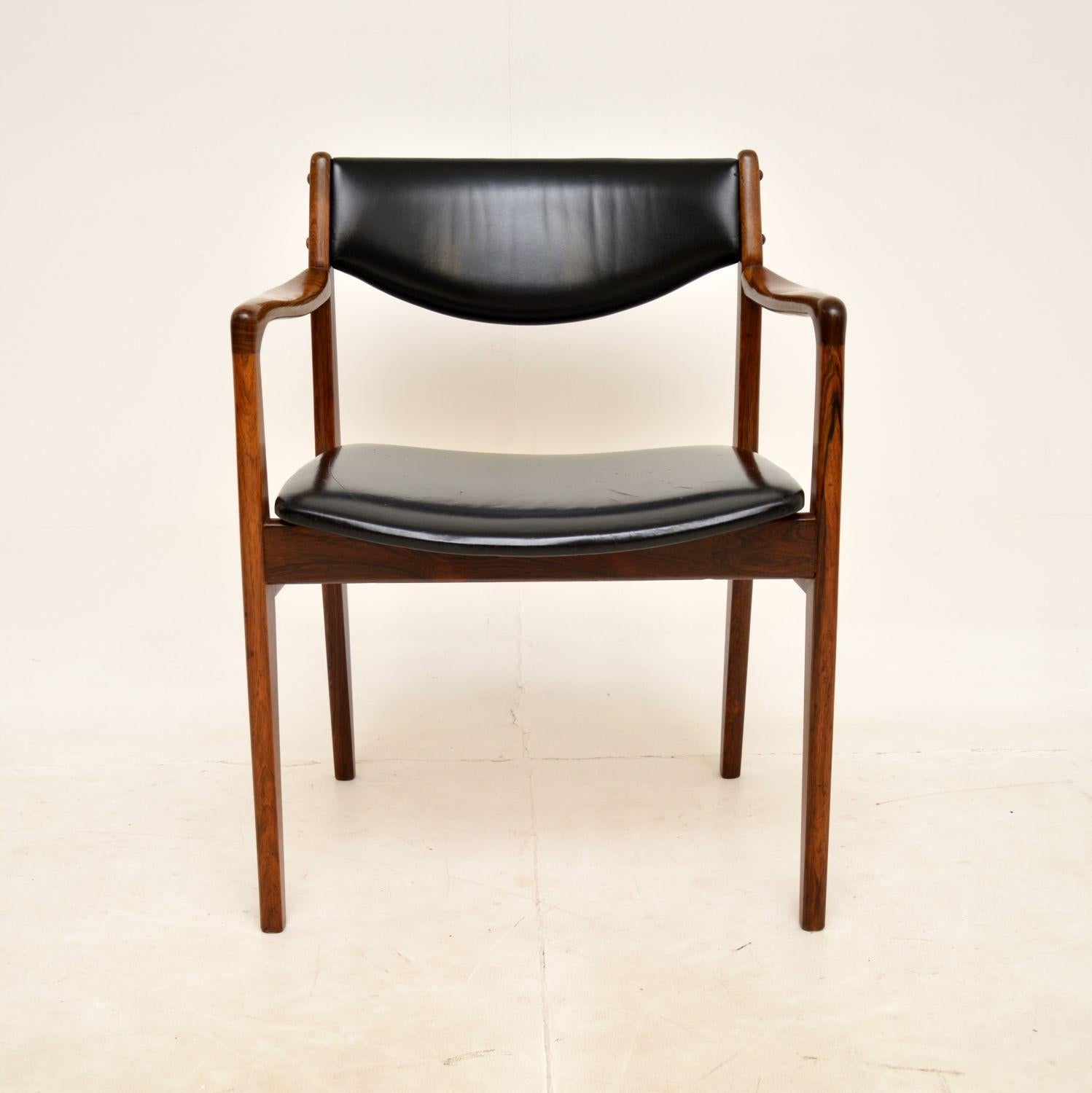 A superb vintage Danish vintage carver armchair in solid wood and black leather. This was made in Denmark by Godtfred H Petersen in the 1960s.
It is of amazing quality, with a gorgeous sweeping frame and high quality leather upholstery. The colour