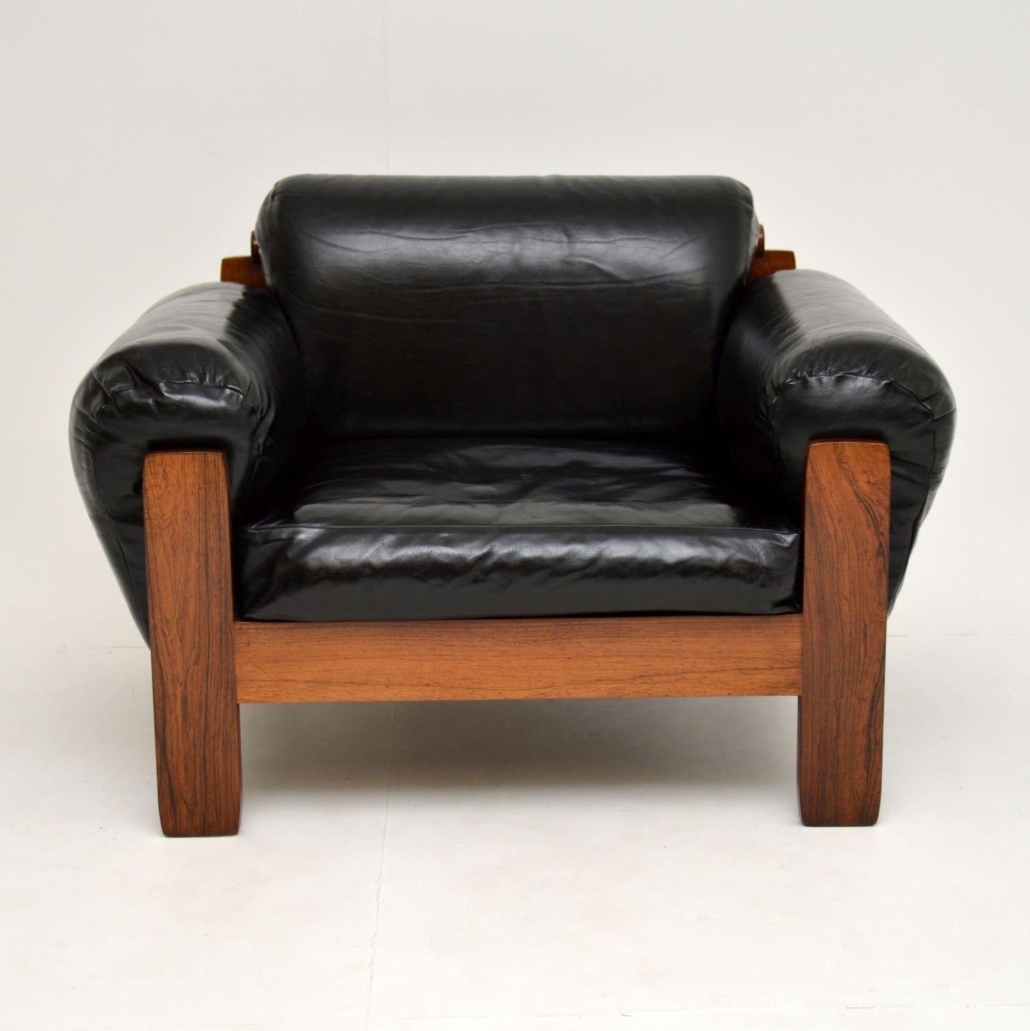 A stylish and unusual vintage armchair in black leather, with a beautiful wood frame. This was made in Denmark and it dates from circa 1960s.

It is of great quality and has a stunning design, with thick padded cushions on the seat, back and