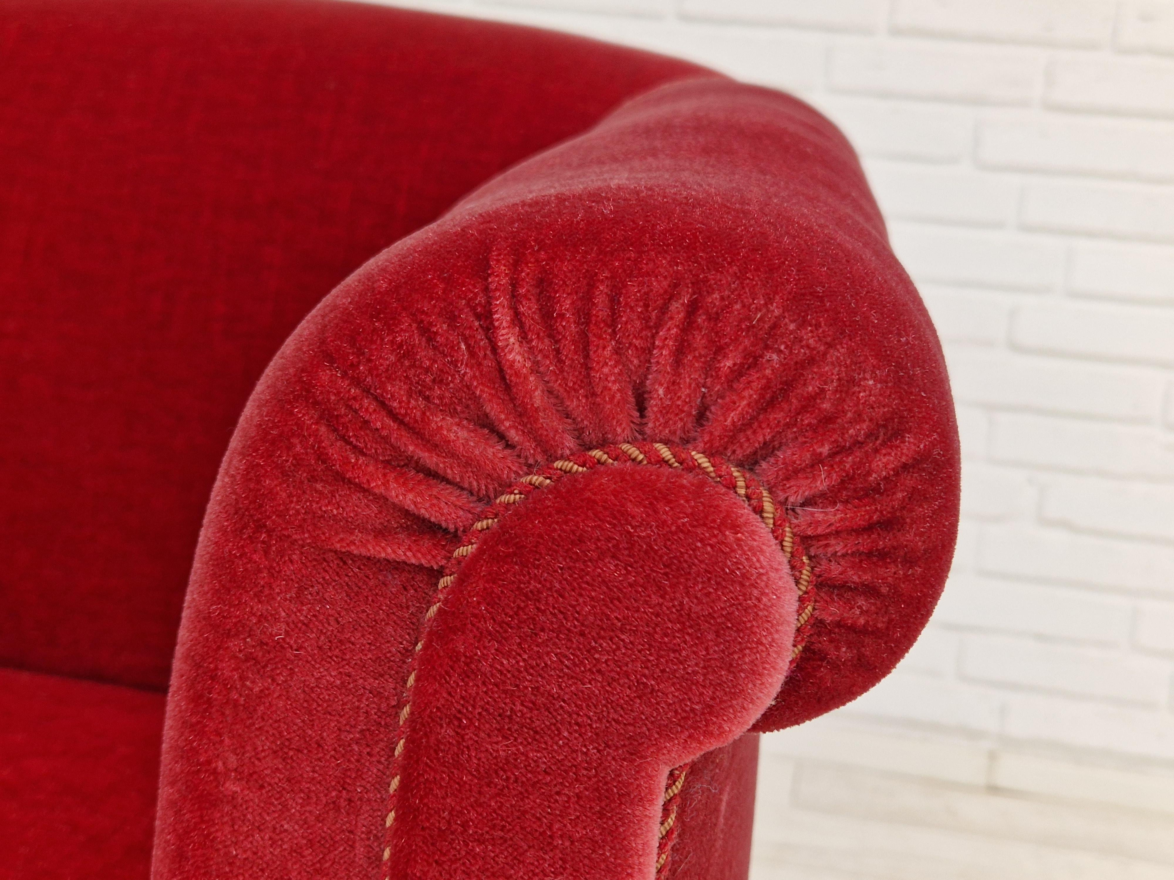 Vintage lounge chair of Danish design. Made about 1960 by a Danish furniture manufacturer. Original cherry-red velvet upholstery in very good condition, no stains, no smells. Legs in beech. Brass springs in the seat.