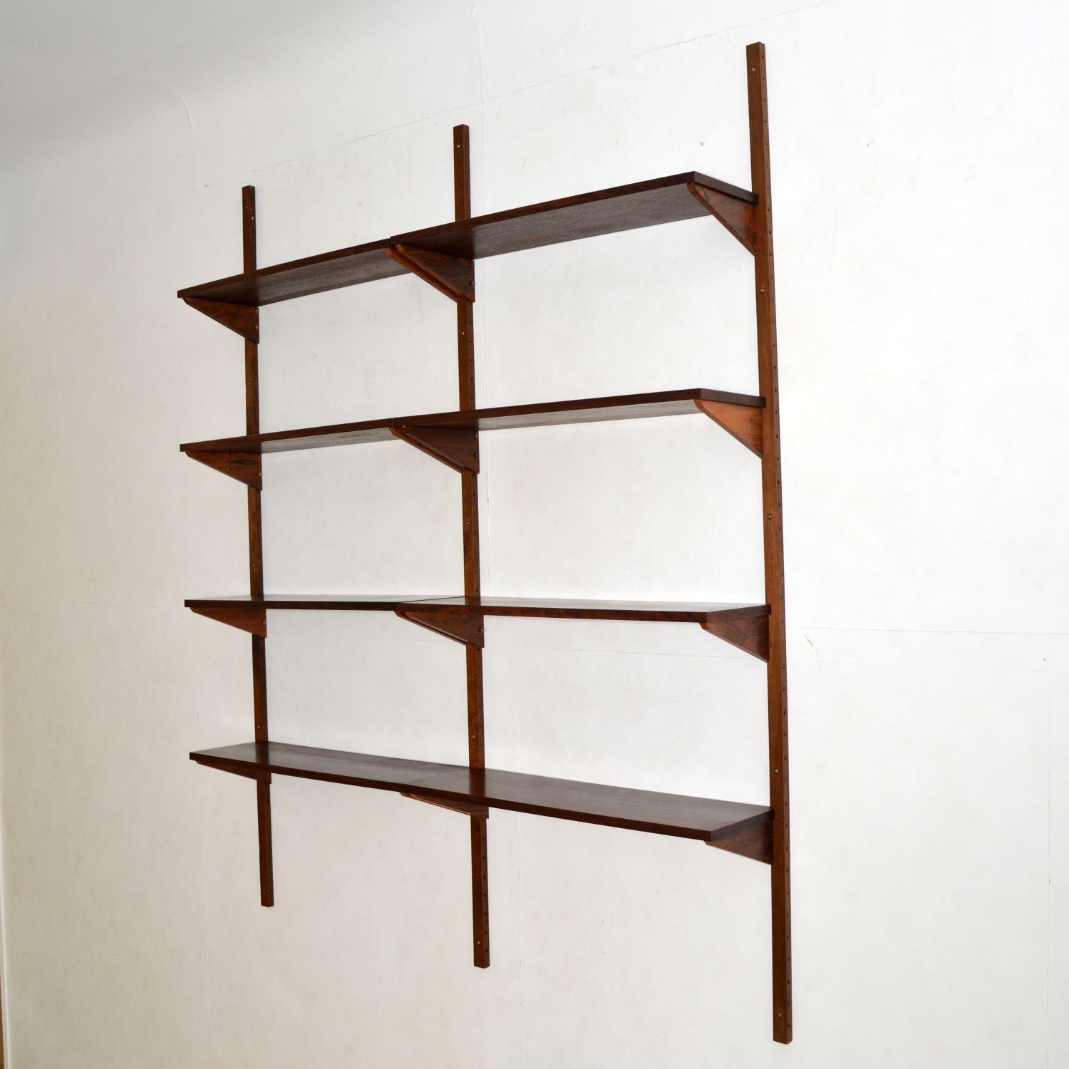 A stylish and practical two bay wall mounting PS shelving system in wood. This was made in Denmark by Randers Mobelfabrik, it was designed by Preben Sorensen, and dates from the 1960’s.

This consists of three wall mounting rails, and eight wood