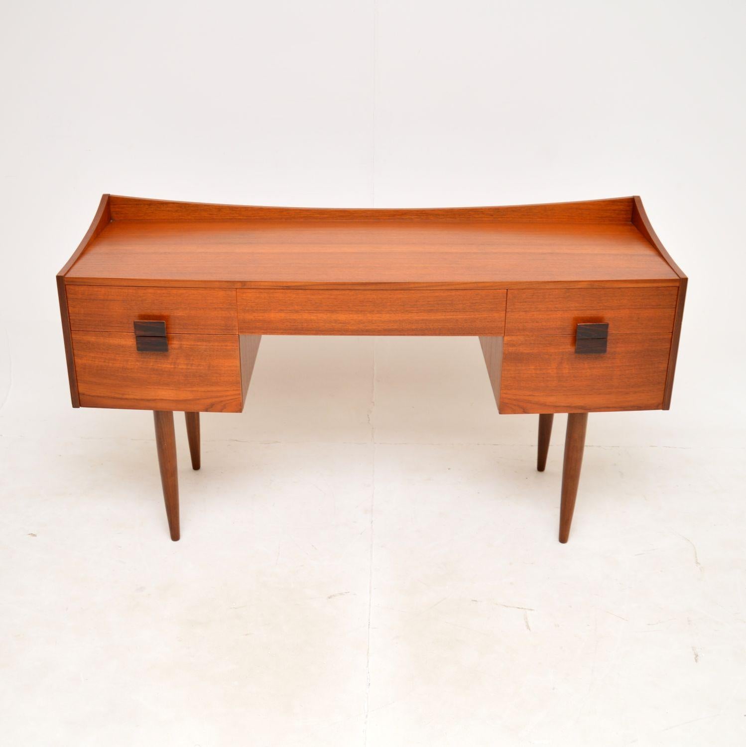 Un bureau vintage en teck de conception danoise, élégant et extrêmement bien fait. Conçue par IB Kofod Larsen pour la gamme danoise de G-Plan, elle a été fabriquée en Angleterre dans les années 1960.
La qualité est étonnante, il s'agit