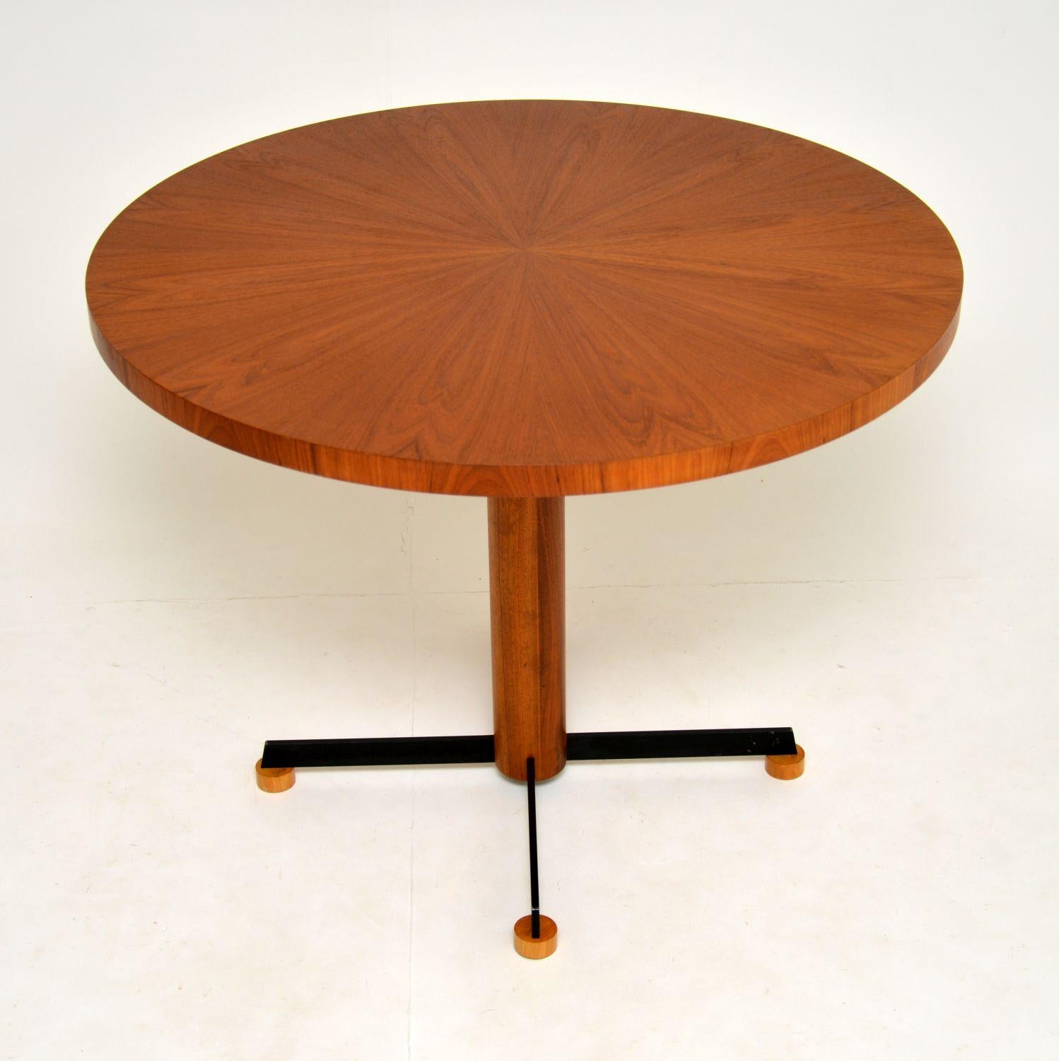 A stylish and top quality vintage teak circular dining table. This was made in Denmark, it dates from circa 1960s-1970s.

The teak top is veneered in a gorgeous sunburst pattern, this sits on a teak column base, with black metal splayed legs