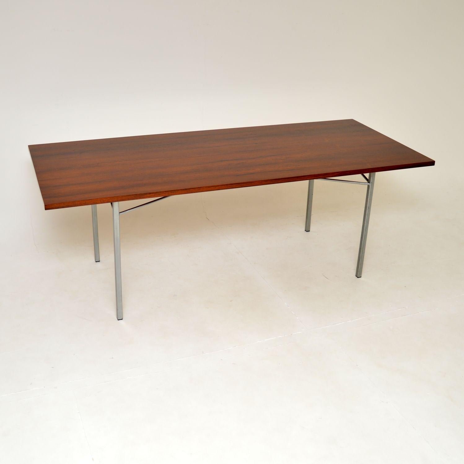 A fantastic vintage Danish dining table in wood with an interesting steel base. This was made in Denmark, it dates from around the 1960’s.

It is of amazing quality with a stylish design, it is also a very useful size. The top is long and quite