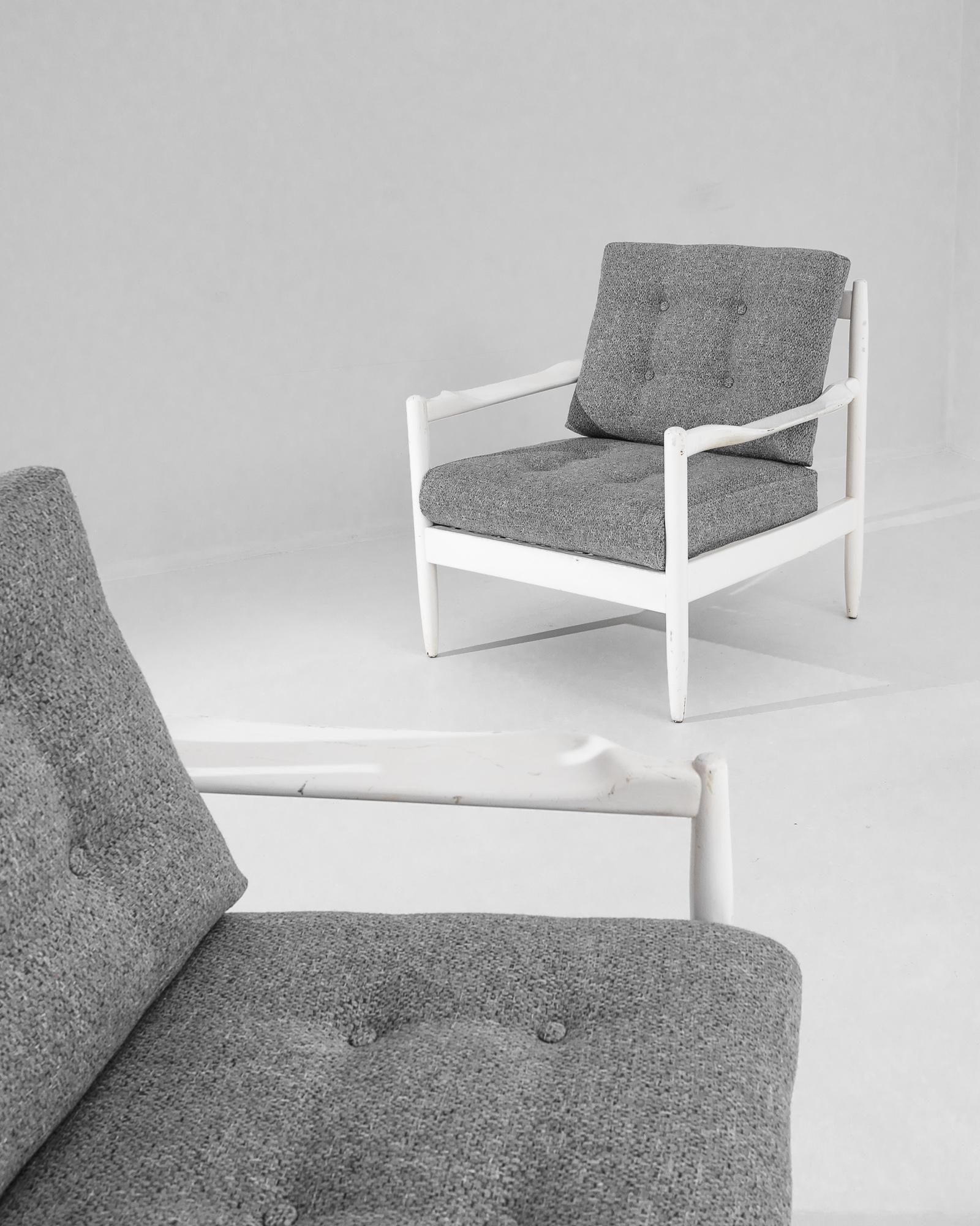 Introducing a pair of 1960s Danish Wooden Armchairs—a timeless tribute to classic Scandinavian design. These one-of-a-kind antique treasures boast sleek white frames that provide a striking contrast with the rich, textured grey upholstery. Each