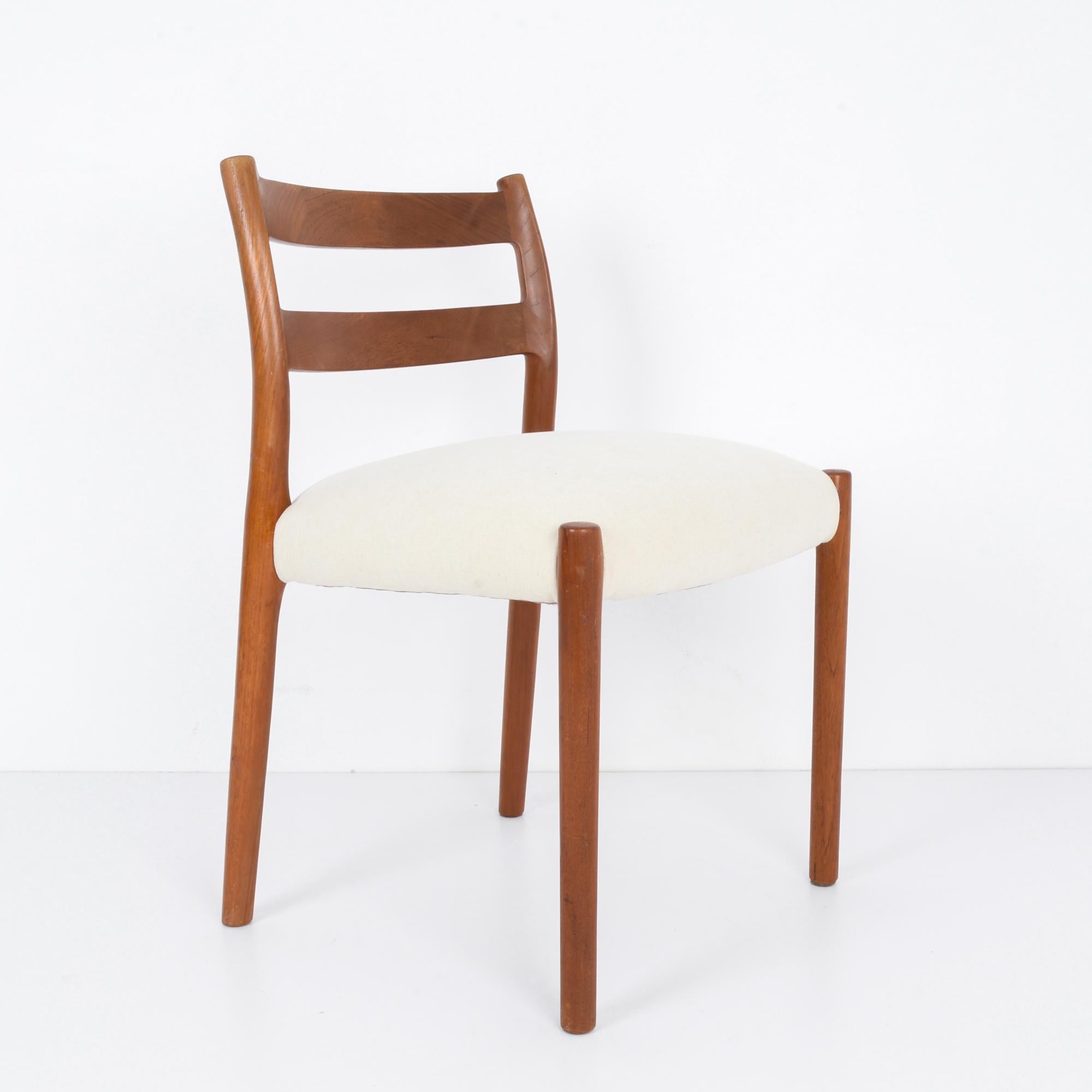 In der innovativen Designlandschaft der 1960er Jahre in Dänemark verkörpert dieser Holzstuhl mit gepolsterter Sitzfläche die schlichte Raffinesse und den ergonomischen Komfort dieser Zeit. Dieses mit viel Liebe zum Detail gefertigte Stück ist der