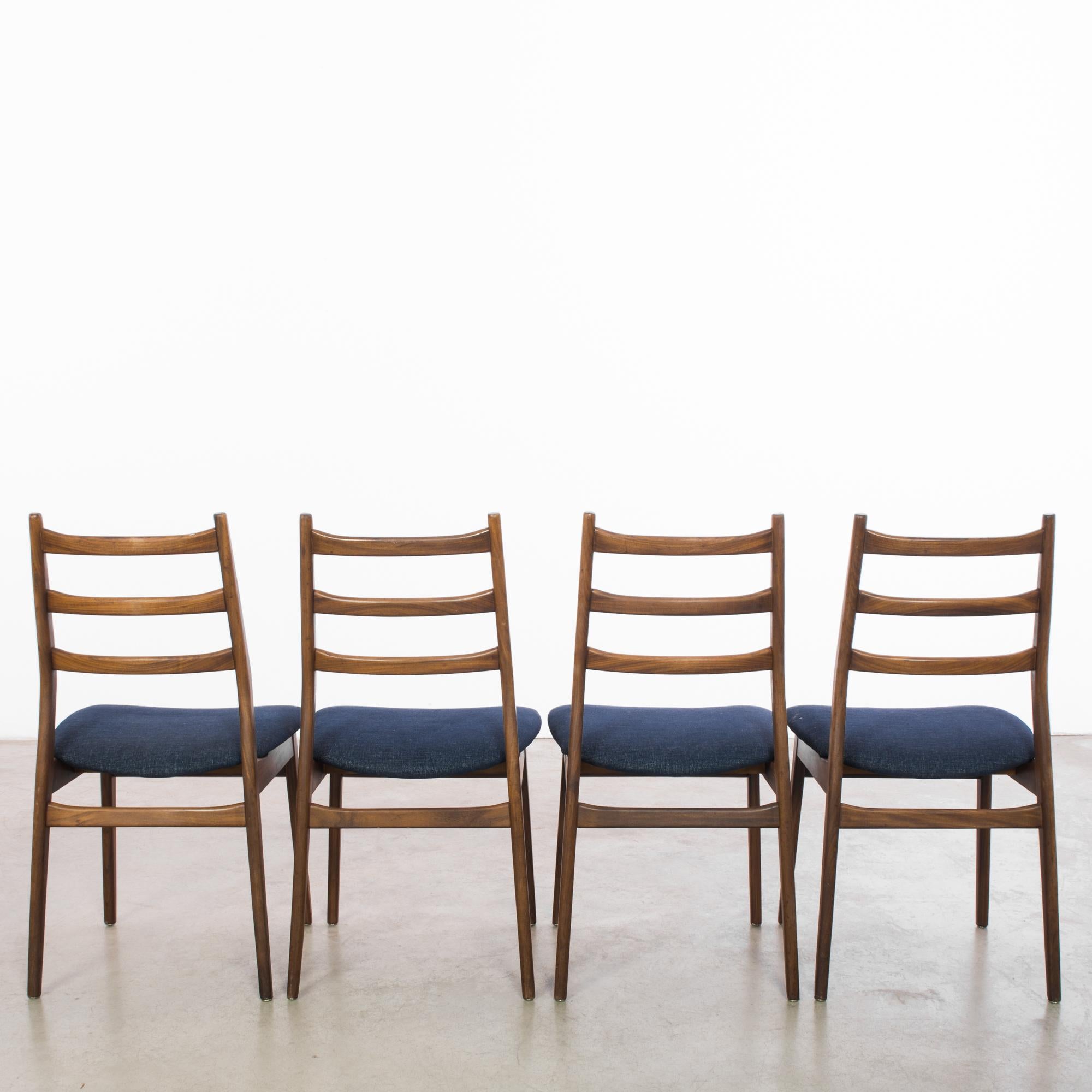 Step into the world of mid-century sophistication with this exquisite set of four 1960s Danish wooden chairs, a perfect blend of functionality and minimalist elegance. The warm teak wood frames exhibit the sleek lines and beautiful grain that are