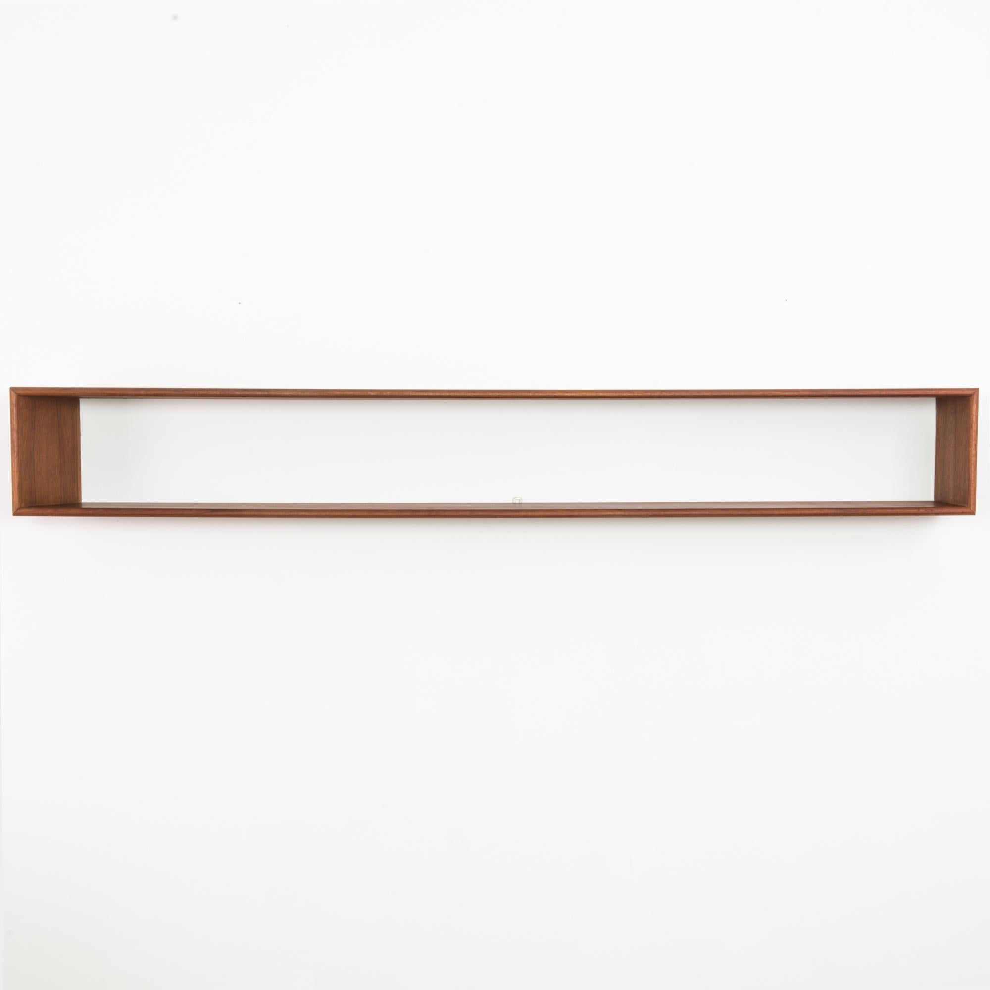 This wooden wall shelf was made in Denmark, circa 1960. With its simple, rectangular silhouette and smooth, polished wood, it offers the warmth and functionality of Danish modern design.