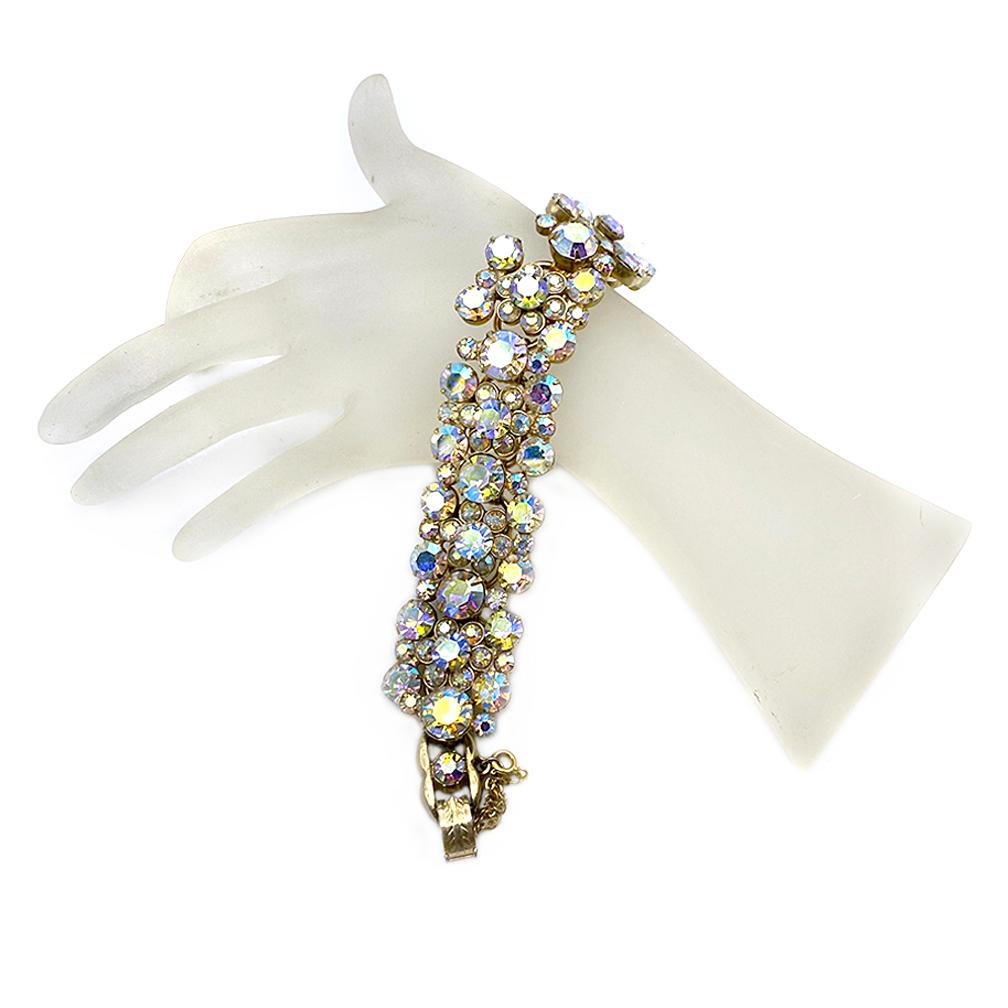 This is an identified Juliana clear aurora borealis chaton flower clusters rhinestone bracelet with gold-tone metal. The prong-set flower spray segments are set on five rings (5 ring links are their bracelet typical construction) with a security