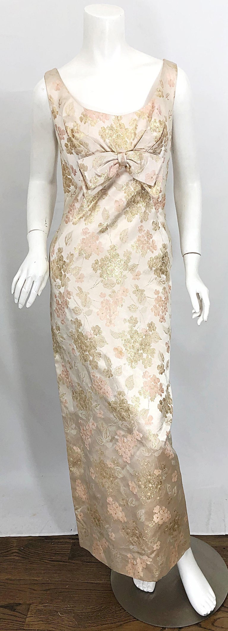 Beautiful 1960s demi couture ivory, light pink and gold metallic flower printed silk gown! Features impeccable construction with heavy attention to details. Tailored bodice with a large bow at center bust. Hidden metal zipper up the back with