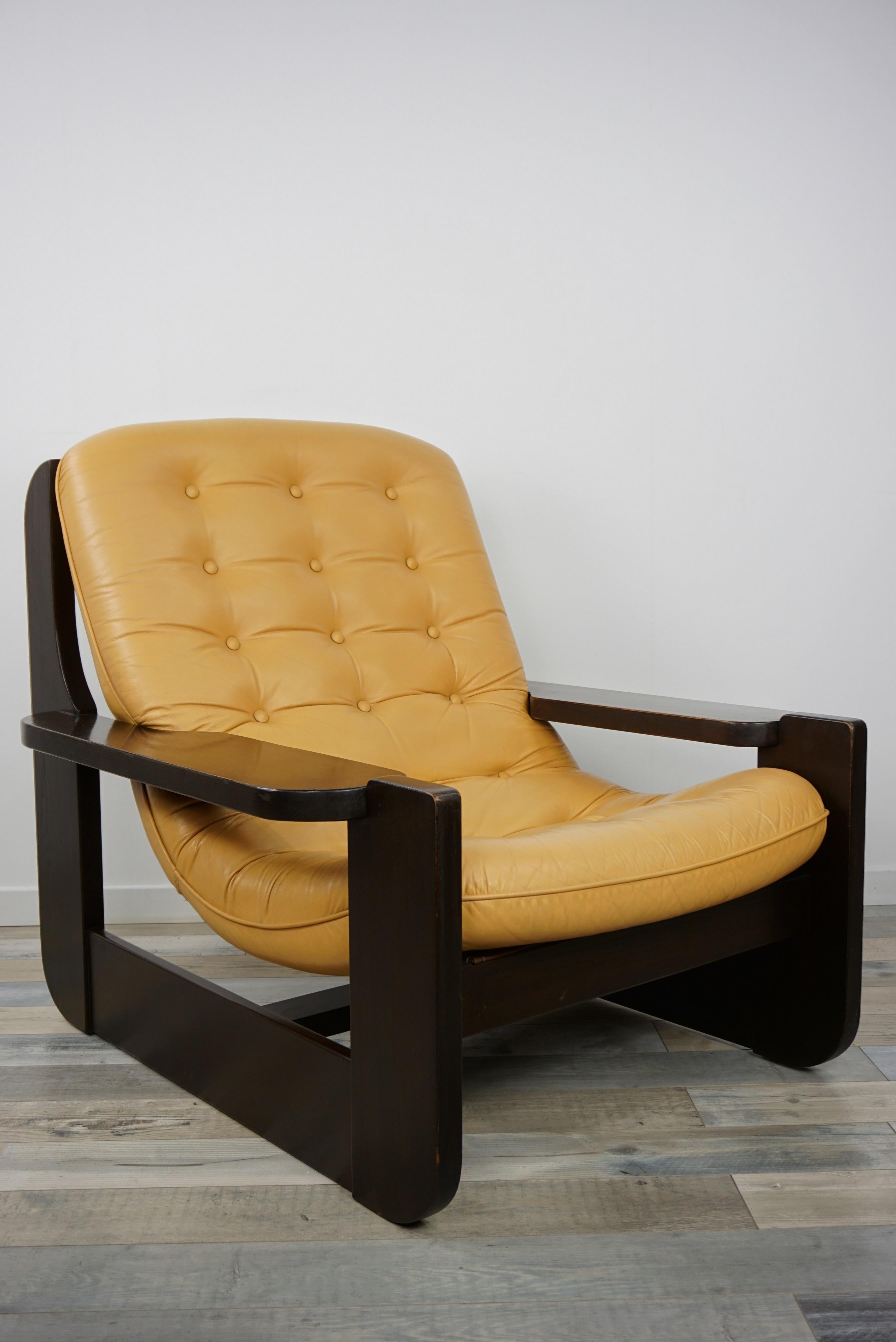 1960s design oak wooden and natural leather lounge armchair composed of a dark brown varnished oak wooden graphic structure with a hanging seat in natural leather. Comfortable and design, amazing and tasty colors like a cookie, all in excellent