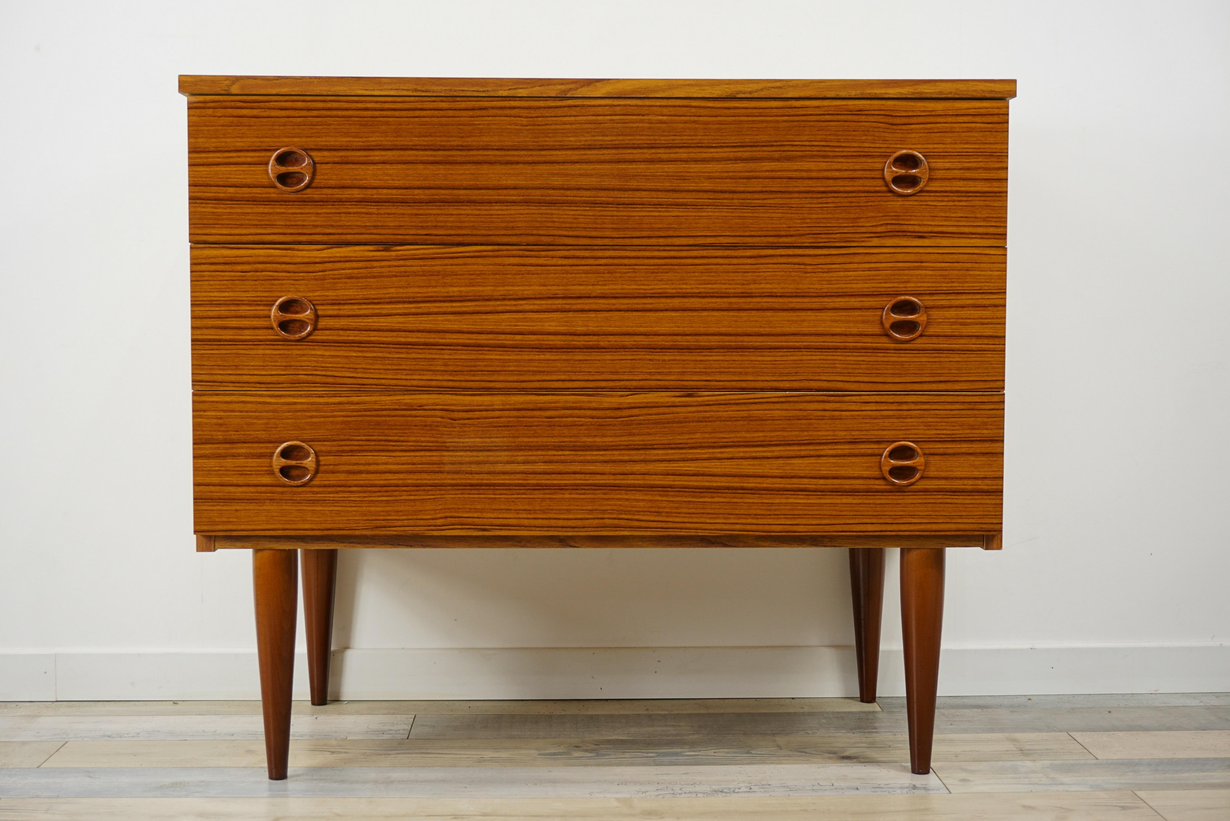 1960s teak wooden chest of drawers composed of three drawers with sculpted wooden handles. In excellent state.