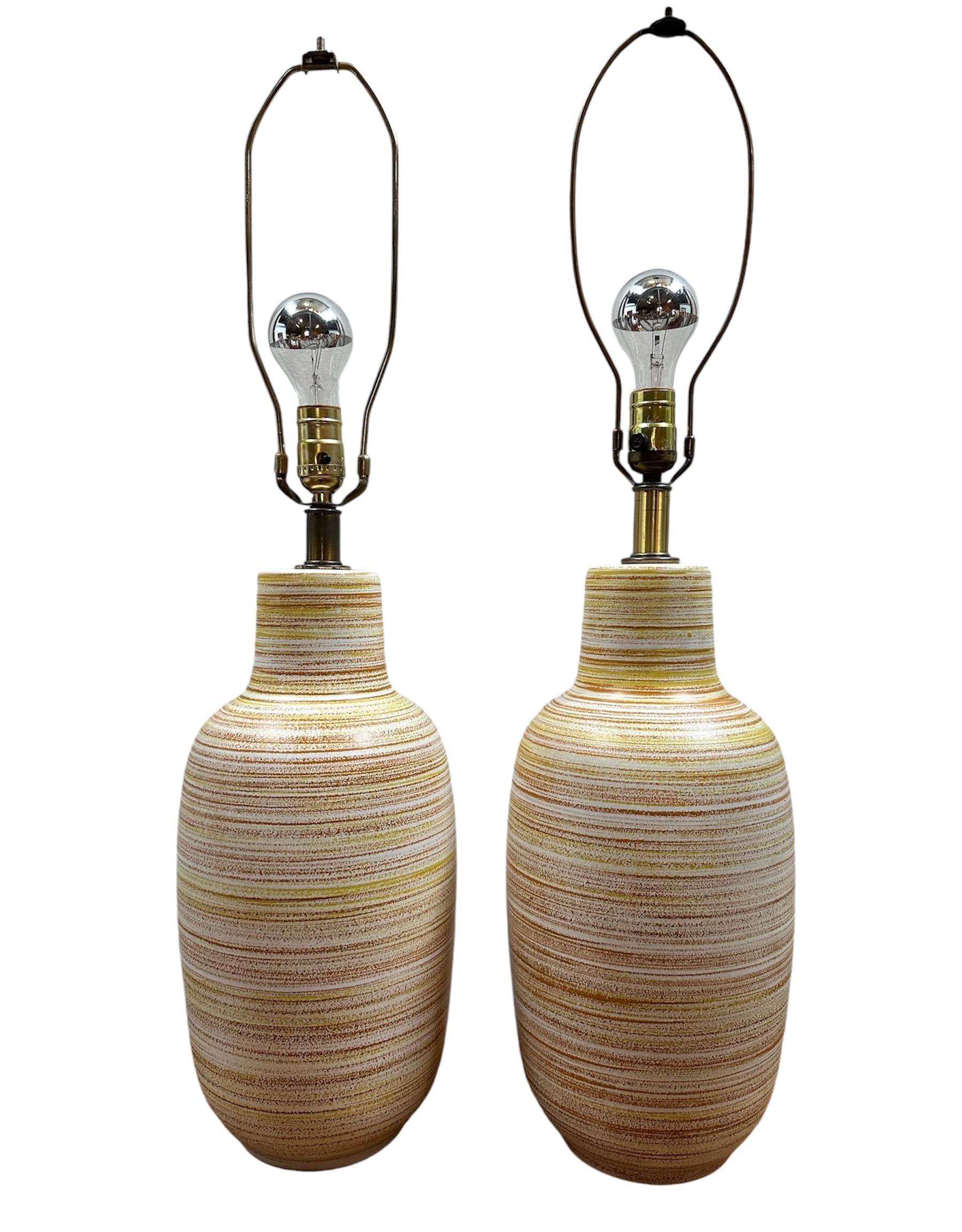 Fabriquée de manière experte dans le style emblématique des années 1960, cette paire de lampes de table en céramique de Design/One apporte une touche de couleur vibrante avec ses teintes orange et jaune. Appréciez le charme et l'éclairage