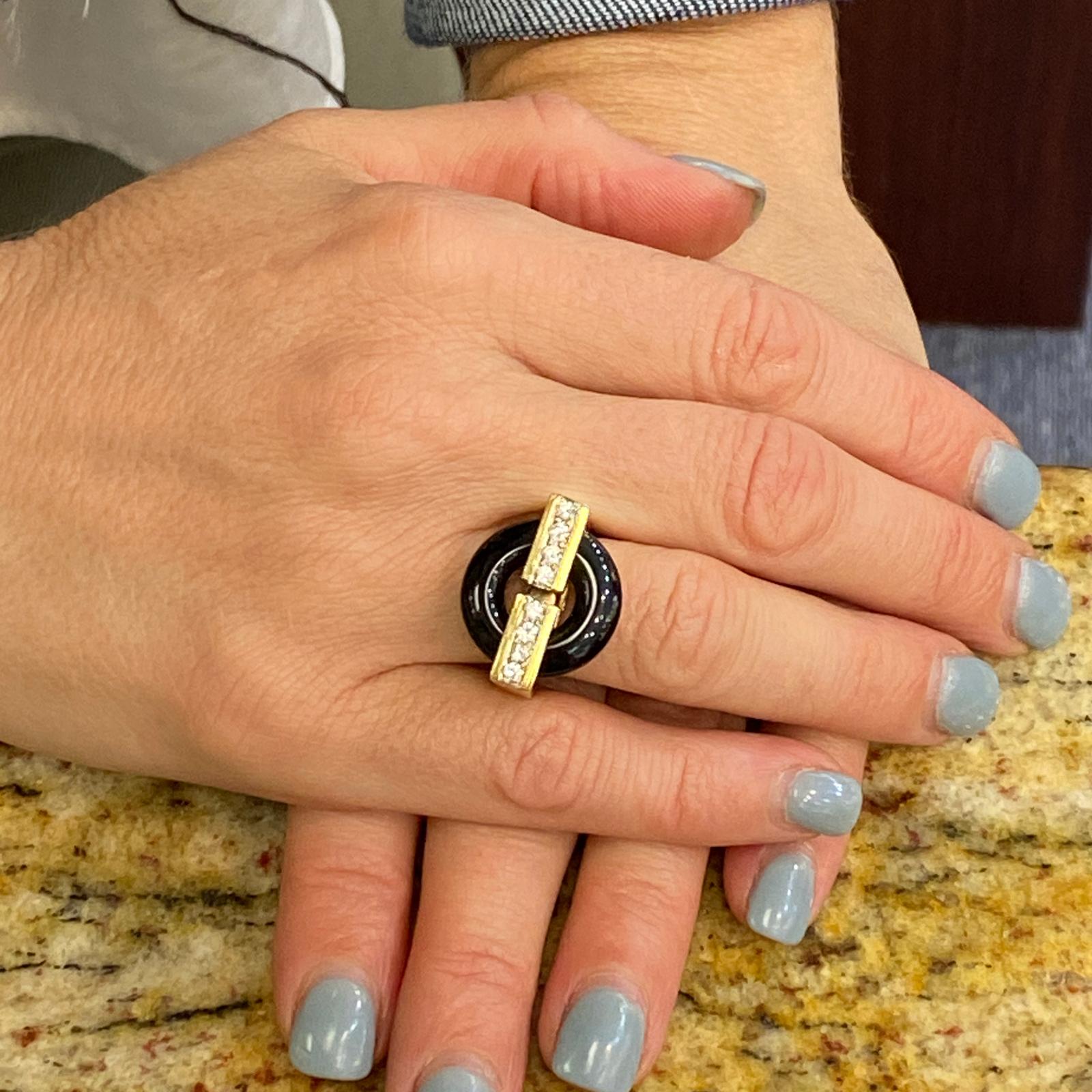 Fabulous 1960's diamond and onyx ring fashioned in 14 karat yellow gold. The ring features 8 round brilliant cut diamonds weighing .40 carat total weight and graded F-G color and VS clarity. The diamonds are set in a row across an open onyx circle.