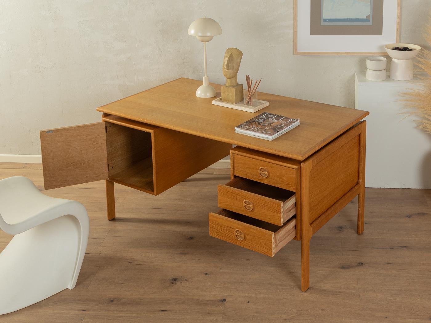 Classic freestanding desk from the 1960s by Arne Vodder. High-quality corpus in oak veneer with three drawers, one door, a floating table top and solid wood legs.
Quality Features:

    accomplished design: perfect proportions and visible attention