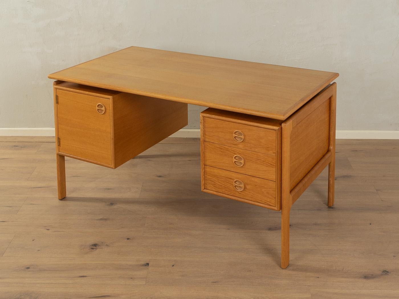 Classic freestanding desk from the 1960s by Arne Vodder. High-quality corpus in oak veneer with three drawers, one door, a floating table top and solid wood legs.

Quality Features:

    accomplished design: perfect proportions and visible attention