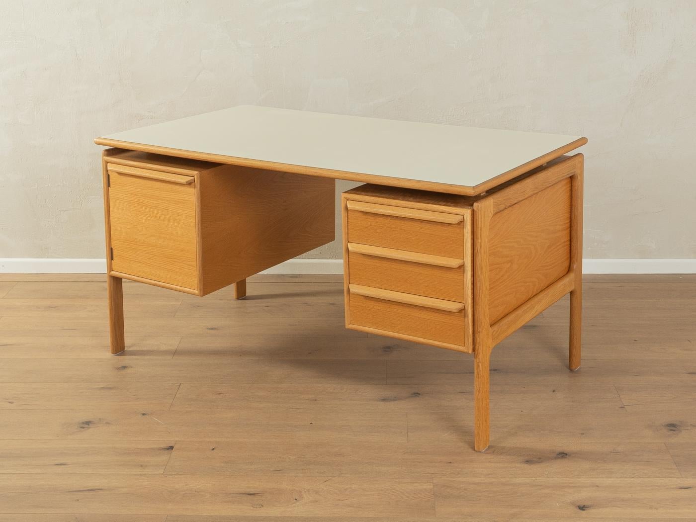 Classic freestanding desk from the 1960s by Arne Vodder. High-quality corpus in oak veneer with three drawers, one door and solid wood legs. The floating table top is coated with creamwhite Formica.

Quality Features:

    accomplished design: