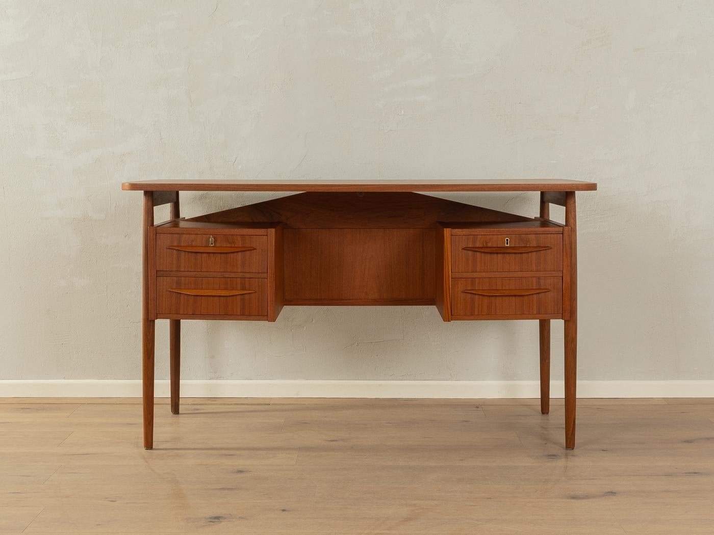 Classic freestanding desk from the 1960s by Gunnar Nielsen Tibergaard. High-quality corpus in teak veneer with four drawers, a floating table top, one bookcase on the rear and solid wood legs.
Quality Features:

    accomplished design: perfect